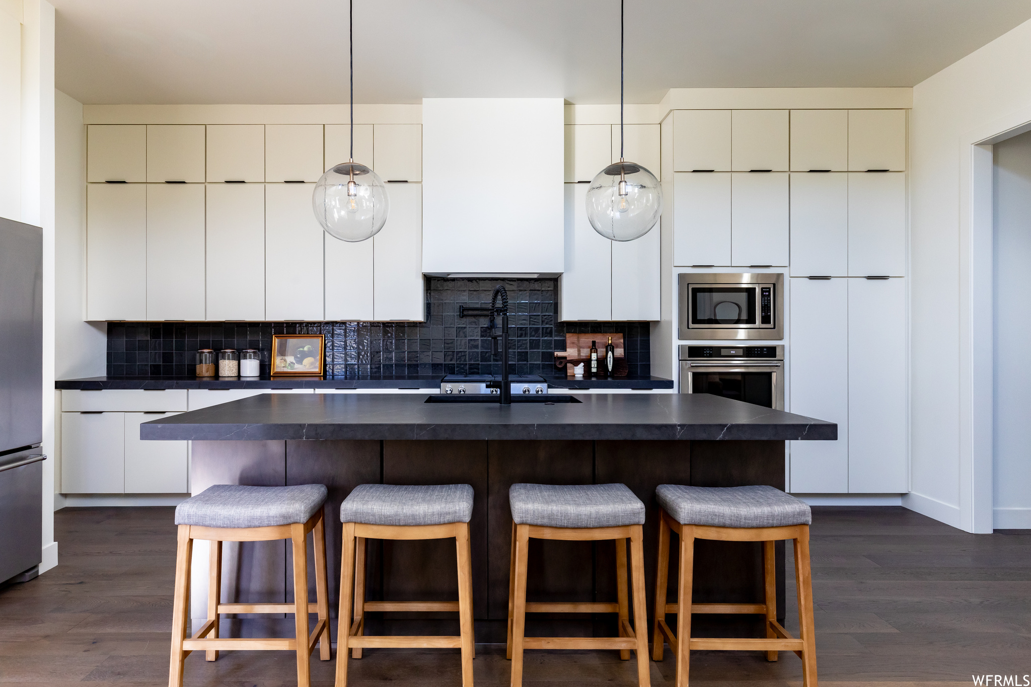 Kitchen featuring dark hardwood / wood-style floors, sink, stainless steel appliances, and backsplash