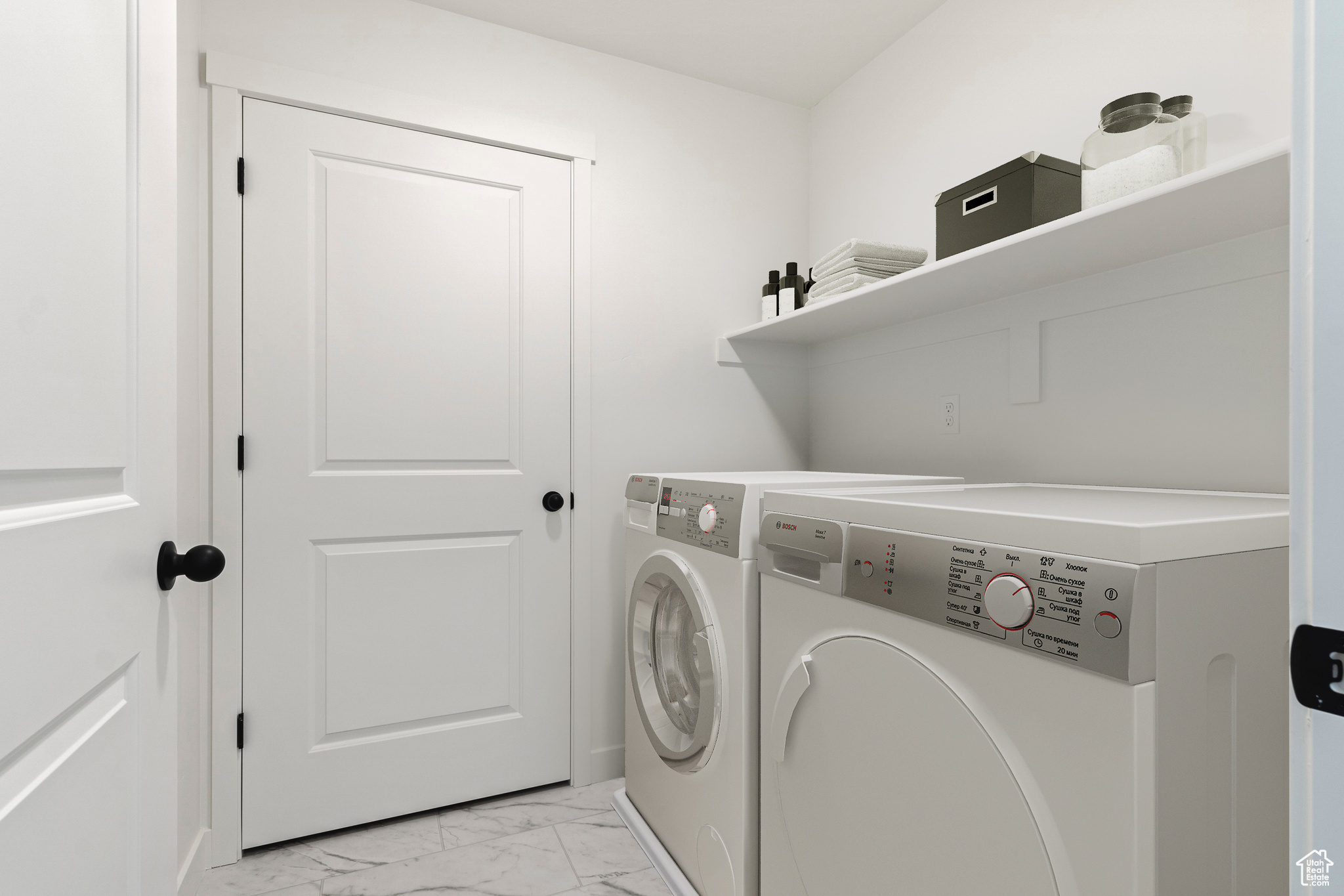Washroom featuring light tile flooring and washing machine and clothes dryer