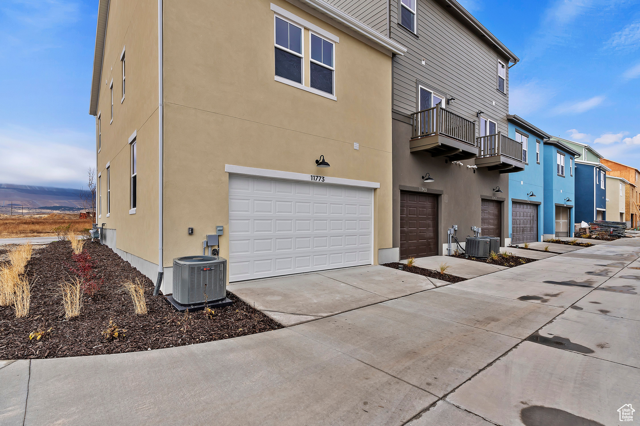 Exterior space with a garage, a balcony, and central air condition unit