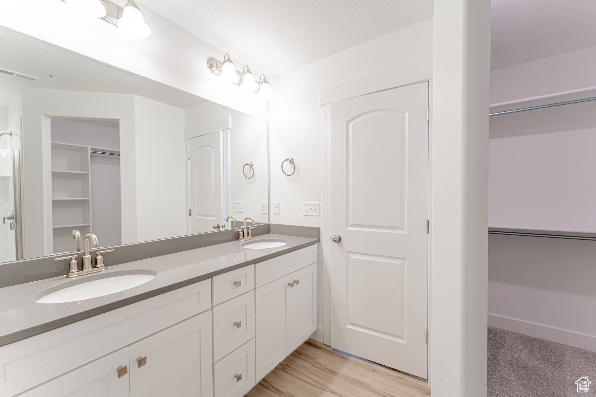 Bathroom featuring hardwood / wood-style floors, large vanity, and double sink