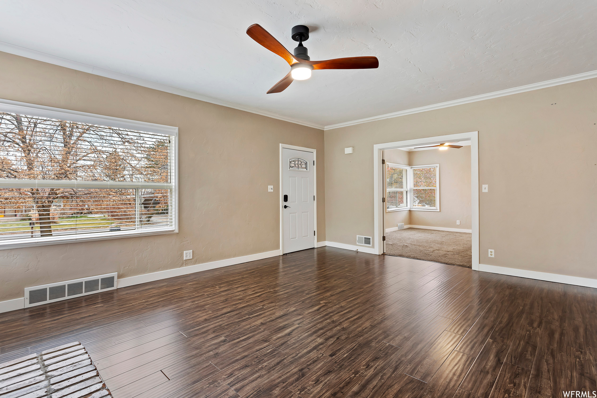 Spare room with dark hardwood / wood-style flooring, ceiling fan, and ornamental molding