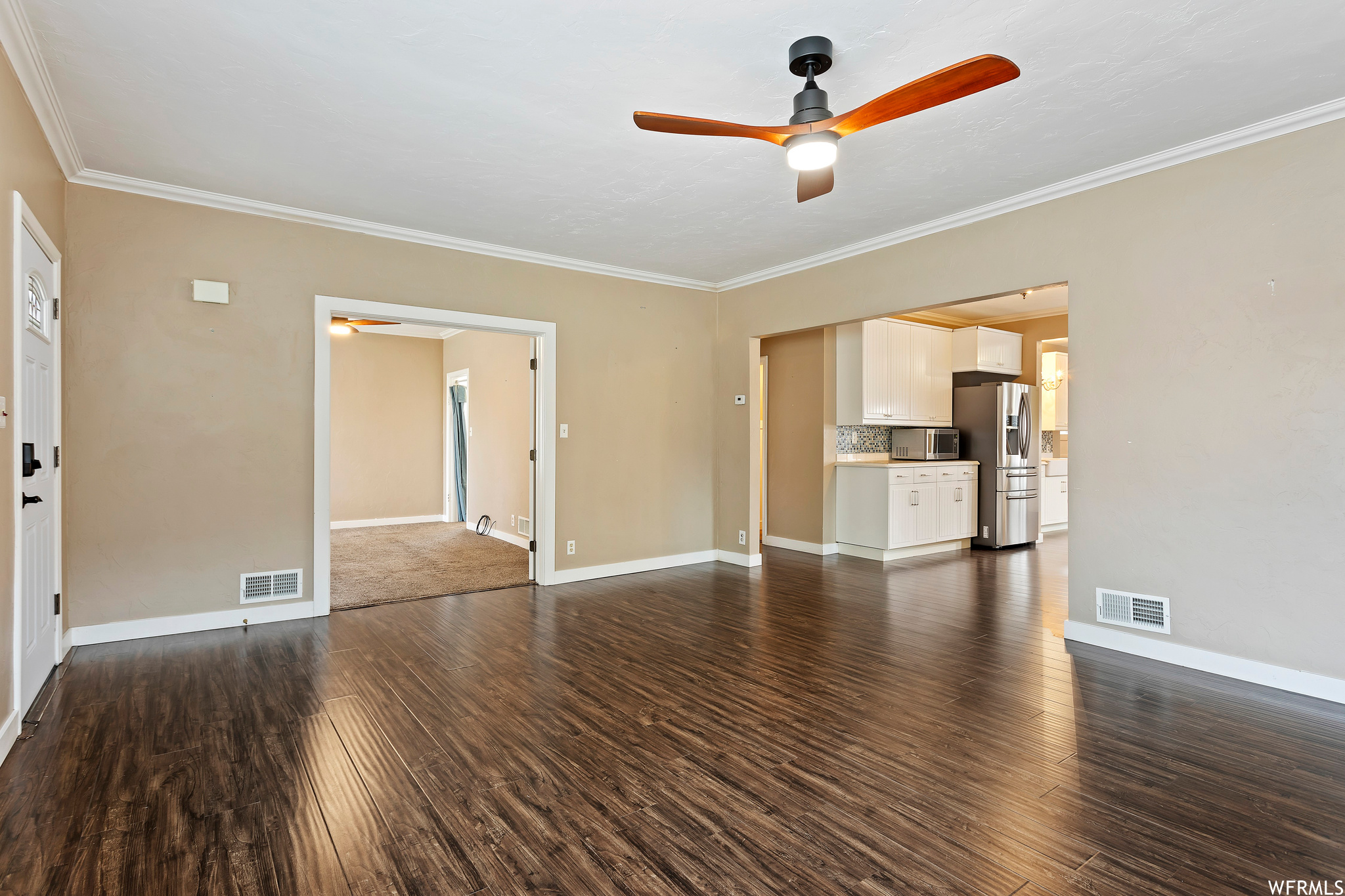 Spare room with ceiling fan, dark hardwood / wood-style flooring, and crown molding