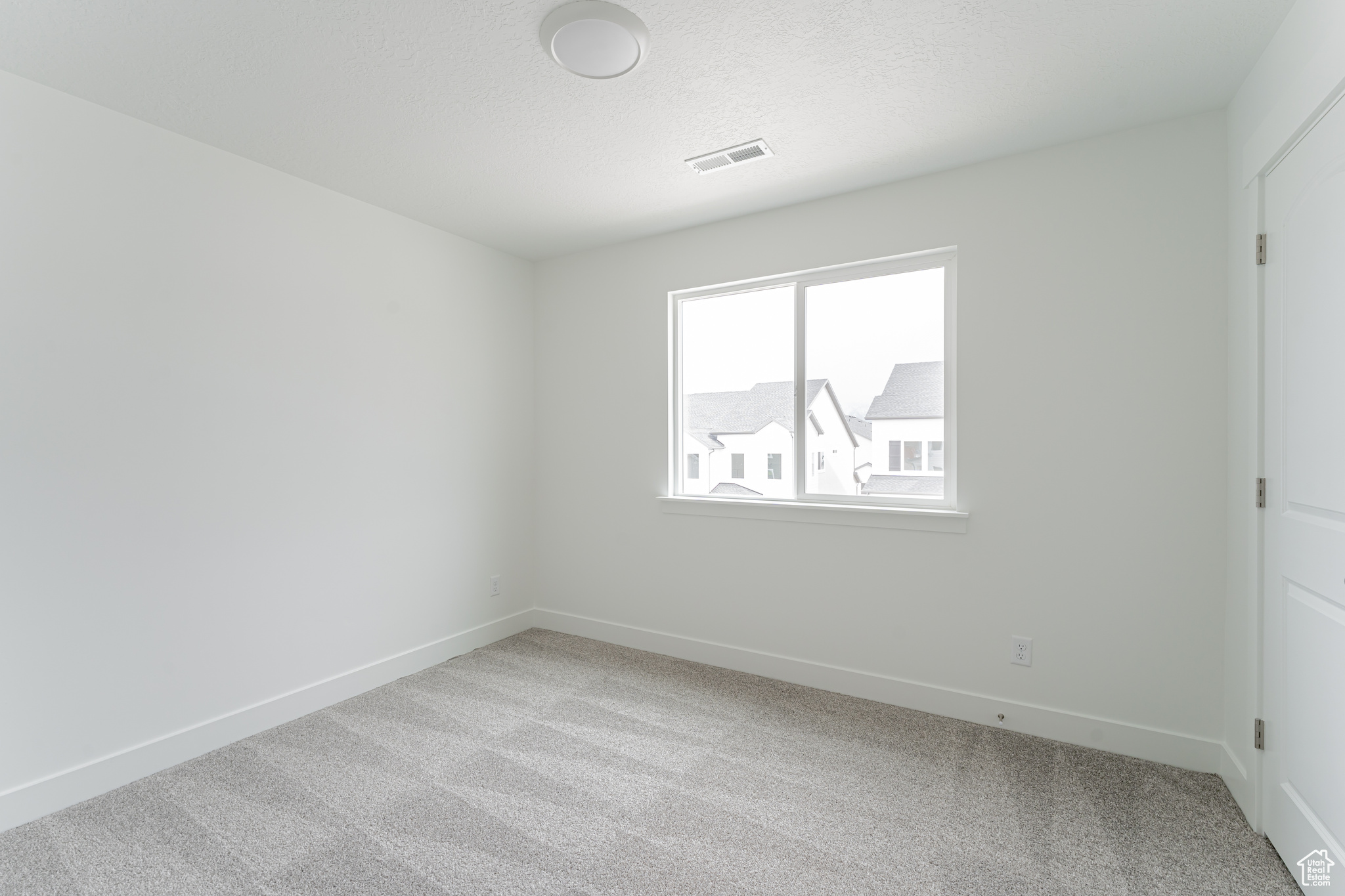 Empty room with light colored carpet