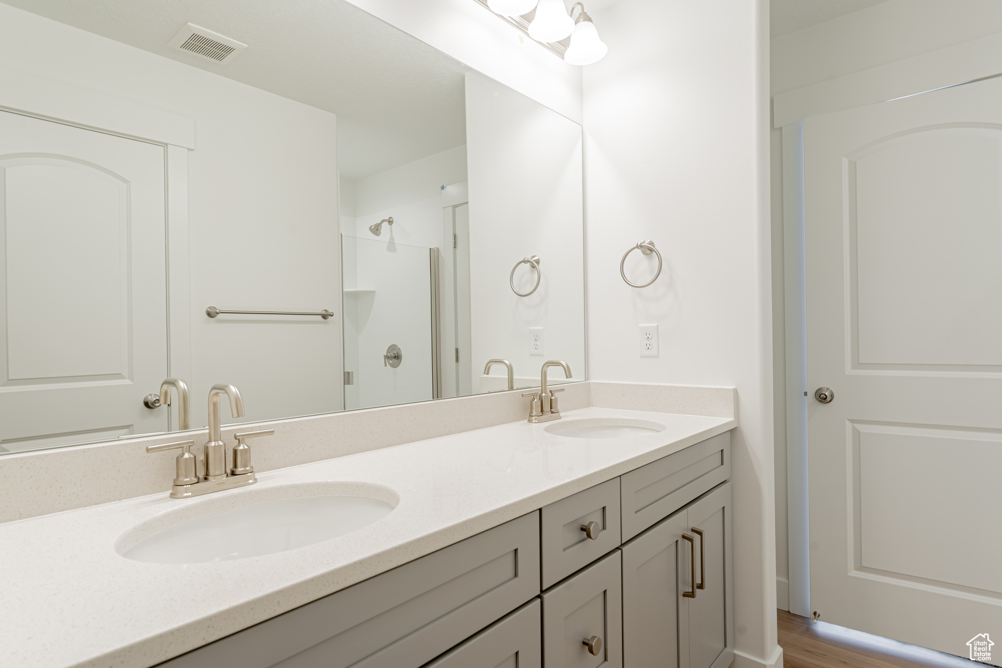Bathroom featuring large vanity, dual sinks, and hardwood / wood-style floors
