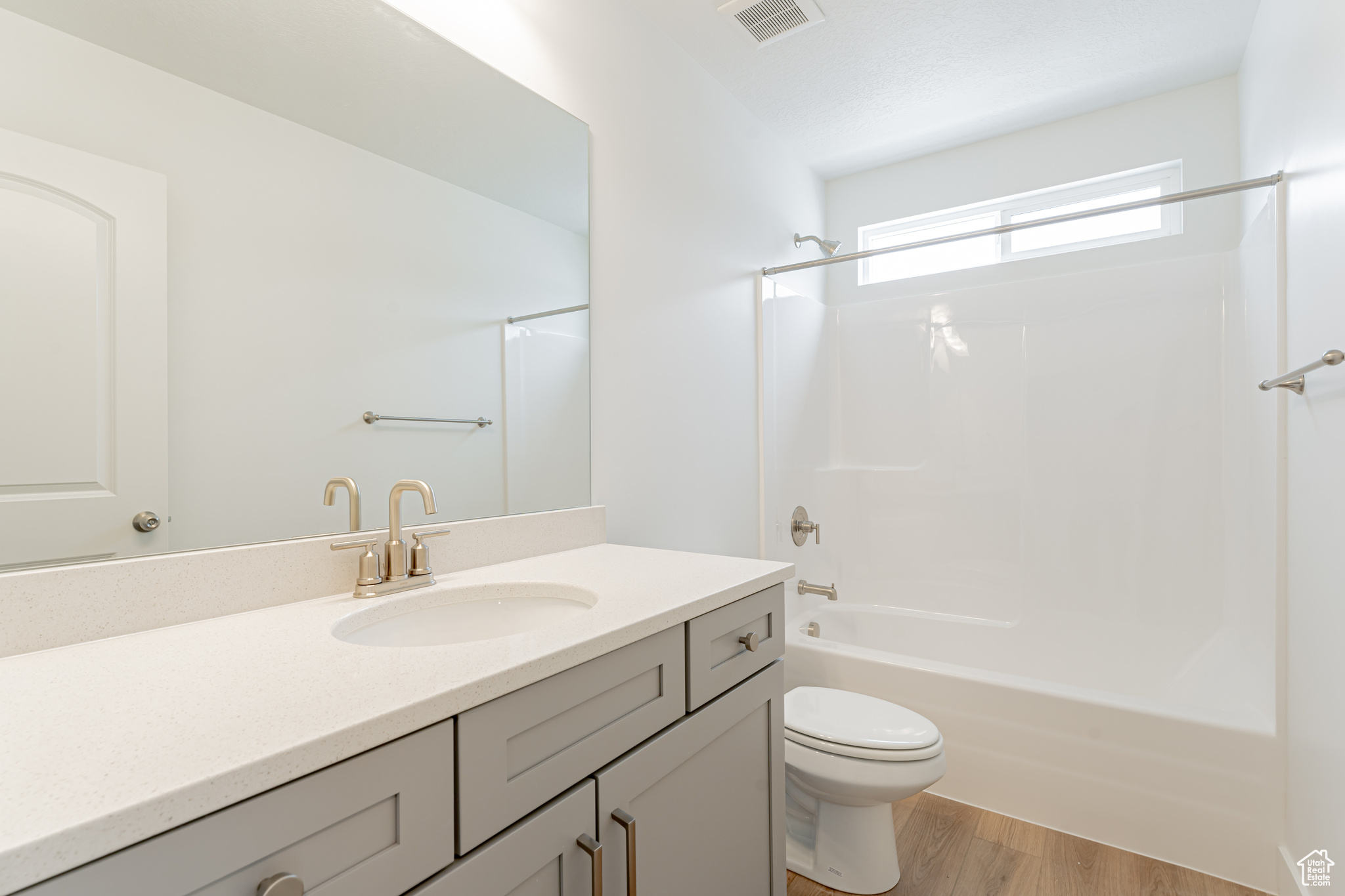 Full bathroom with bathtub / shower combination, toilet, vanity, and hardwood / wood-style flooring