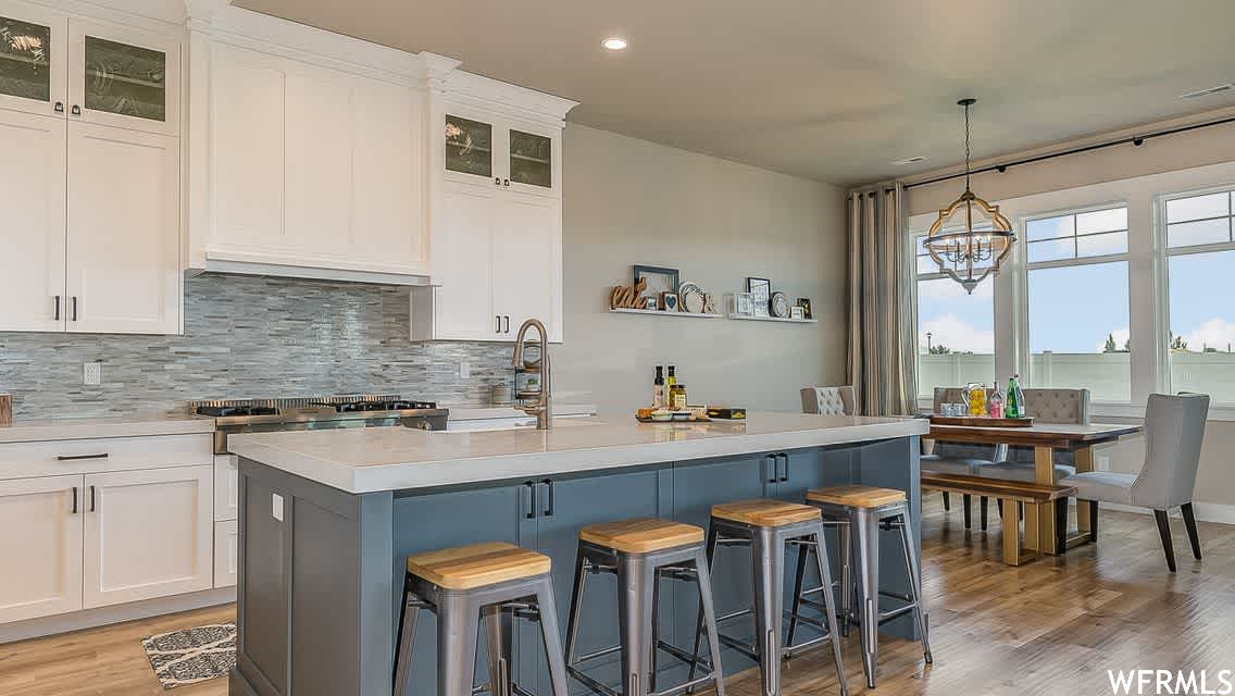 Kitchen with a kitchen island with sink, a breakfast bar, and pendant lighting