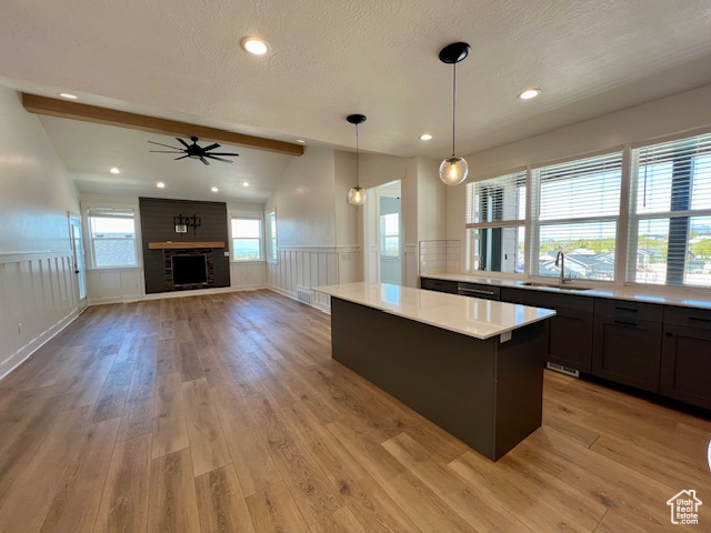 Kitchen with a center island, pendant lighting, sink, light hardwood / wood-style floors, and ceiling fan