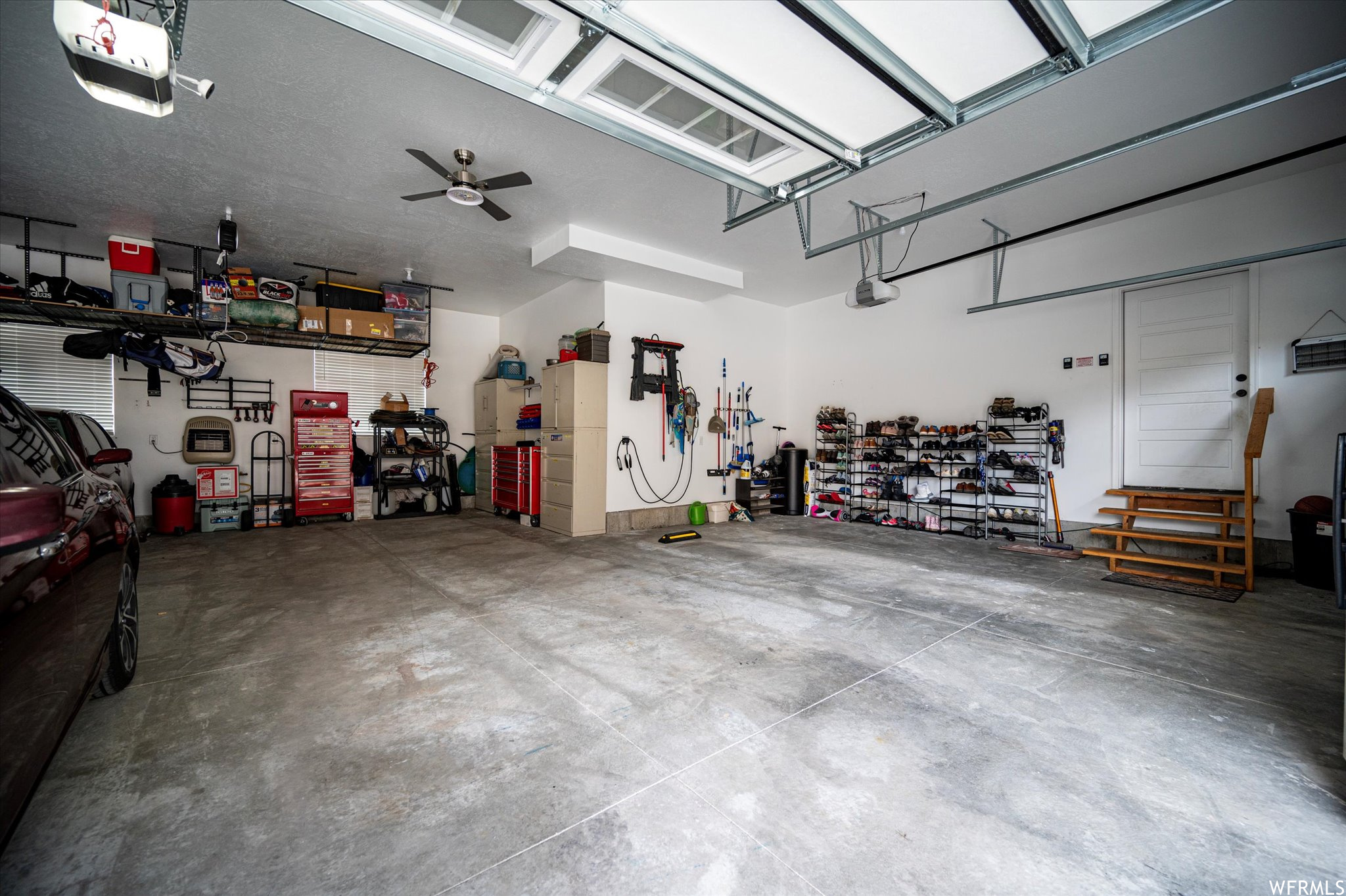 Garage featuring a workshop area, ceiling fan, and a garage door opener