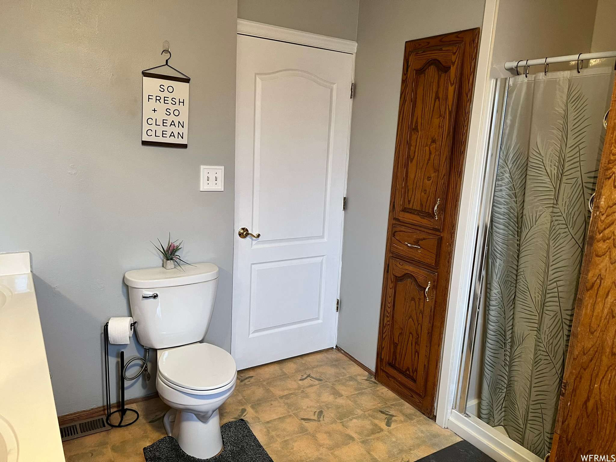 Bathroom featuring toilet, storage and vanity