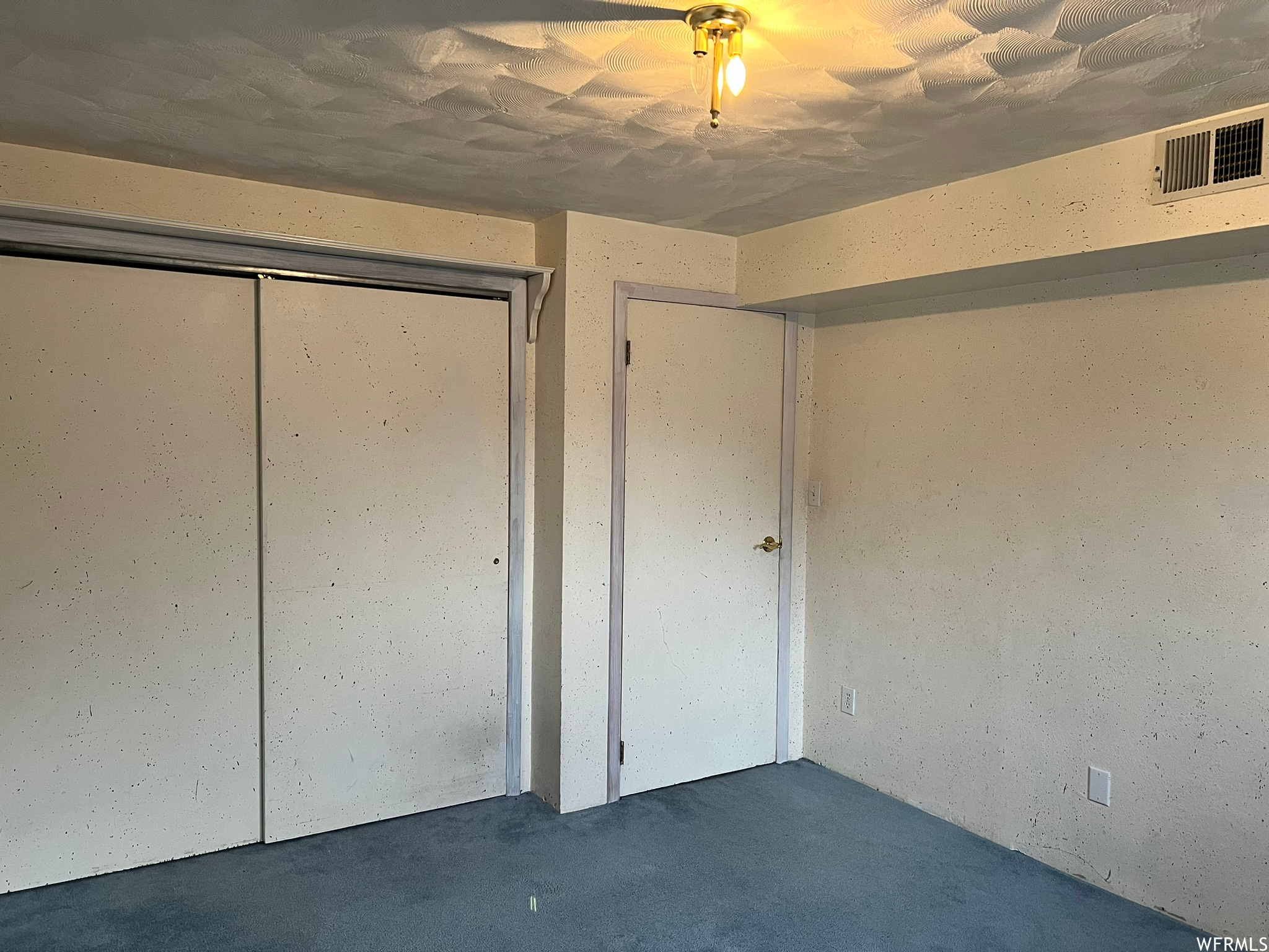 Interior bedroom space with carpet.