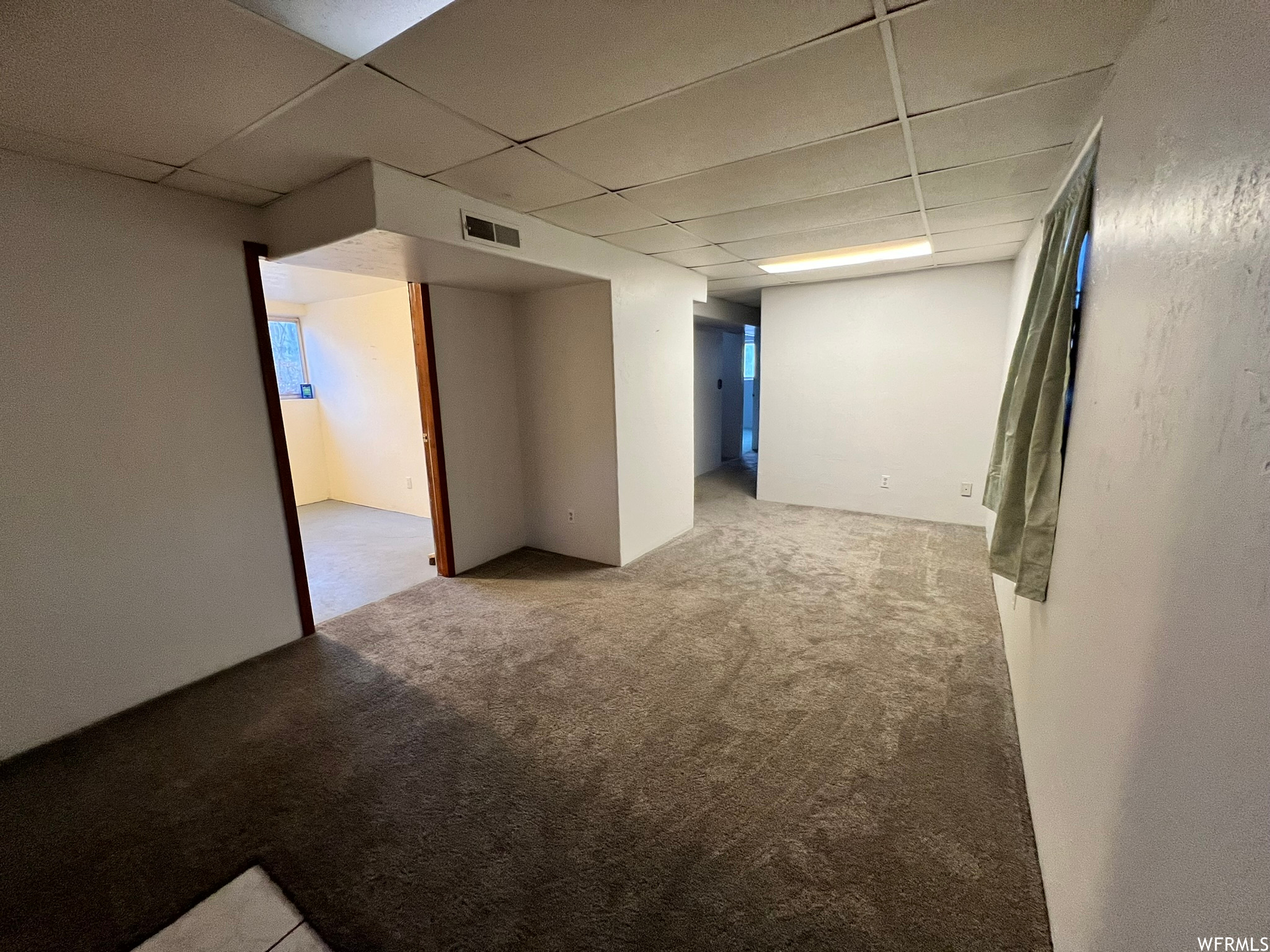 Family room featuring light colored carpet and a paneled ceiling