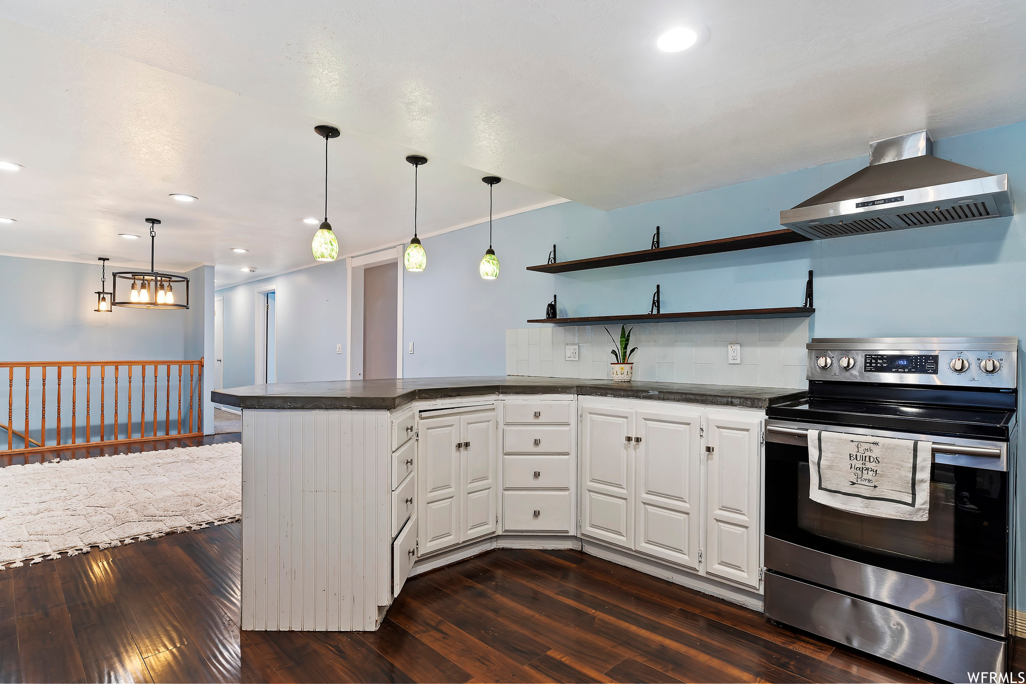 Kitchen with wall chimney range hood, white cabinetry, stainless steel electric range, dark hardwood / wood-style floors, and backsplash