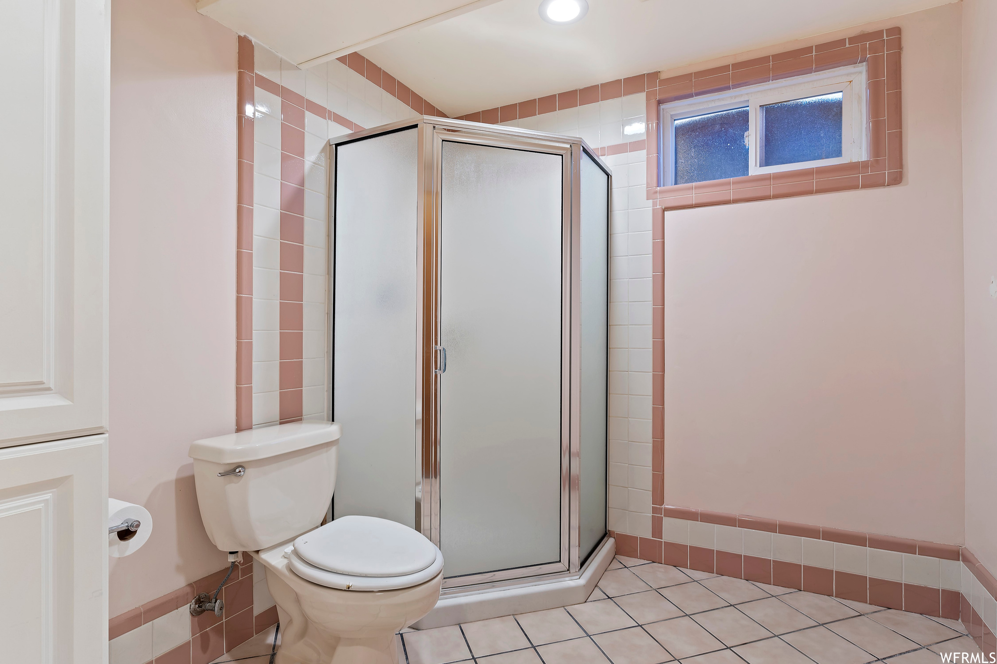 Bathroom featuring toilet, tile flooring, and walk in shower