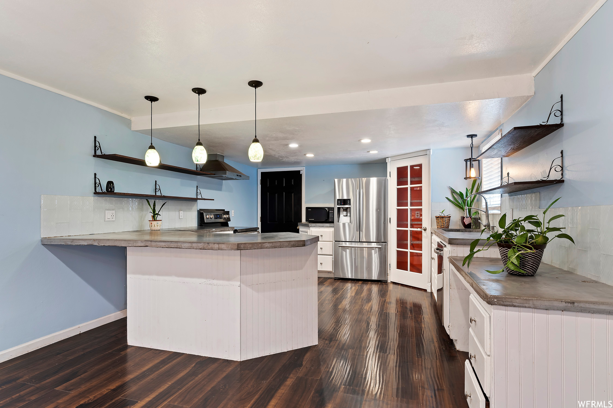 Kitchen featuring pendant lighting, dark wood-type flooring, white cabinets, and stainless steel appliances