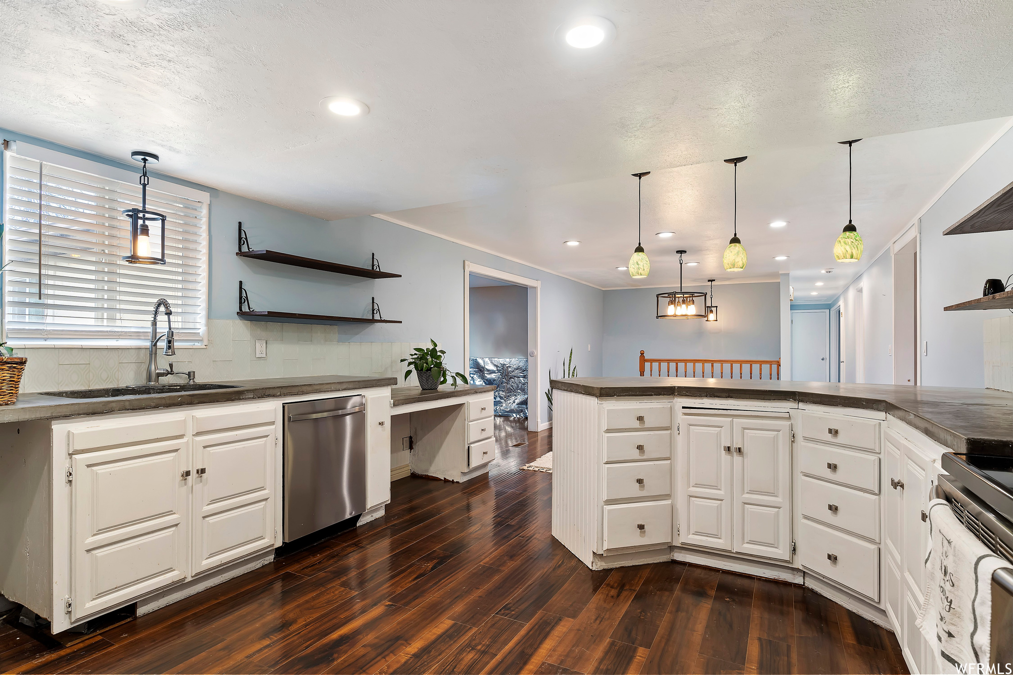 Kitchen featuring white cabinets, dark hardwood / wood-style floors, appliances with stainless steel finishes, and sink