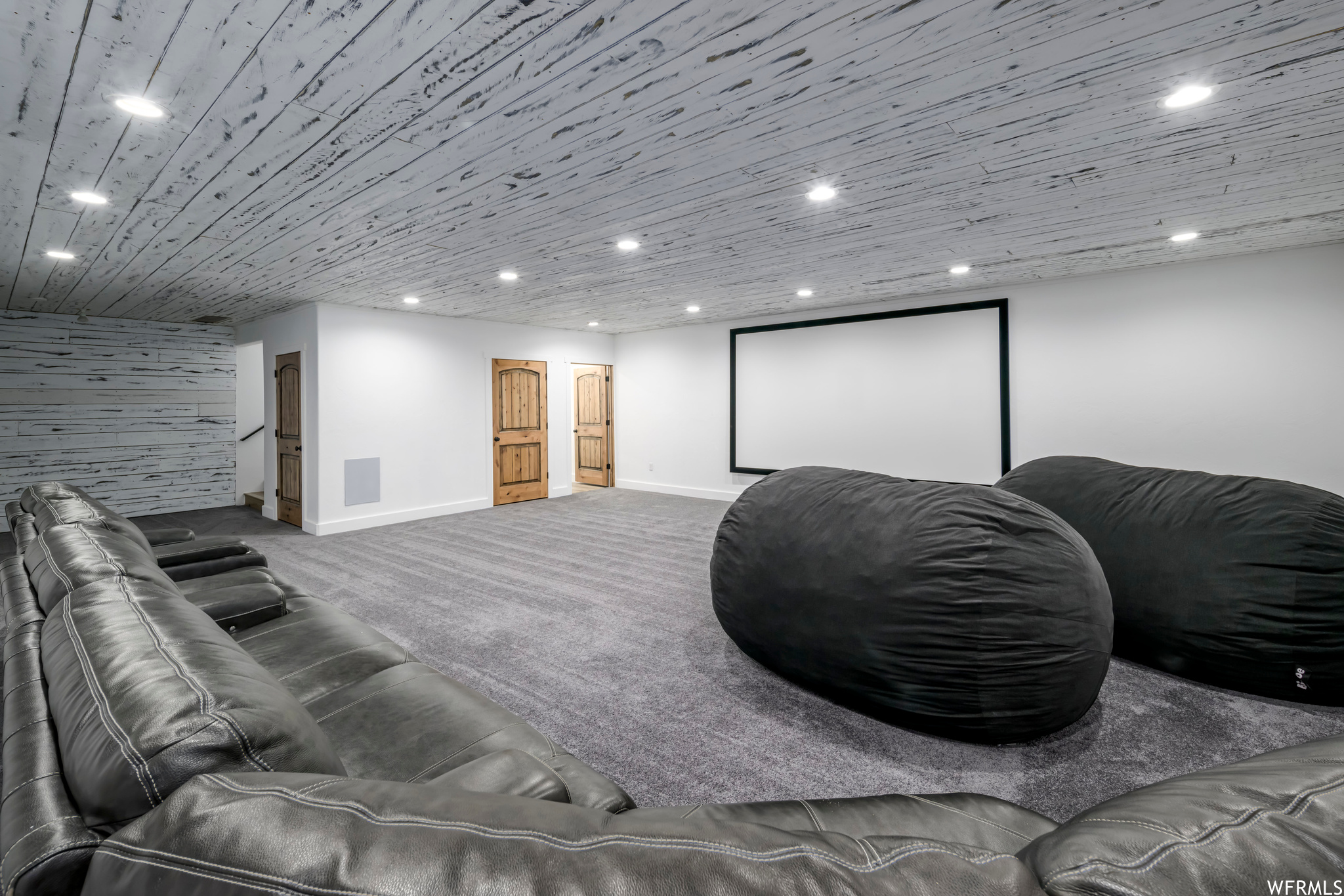 Carpeted home theater with wooden ceiling