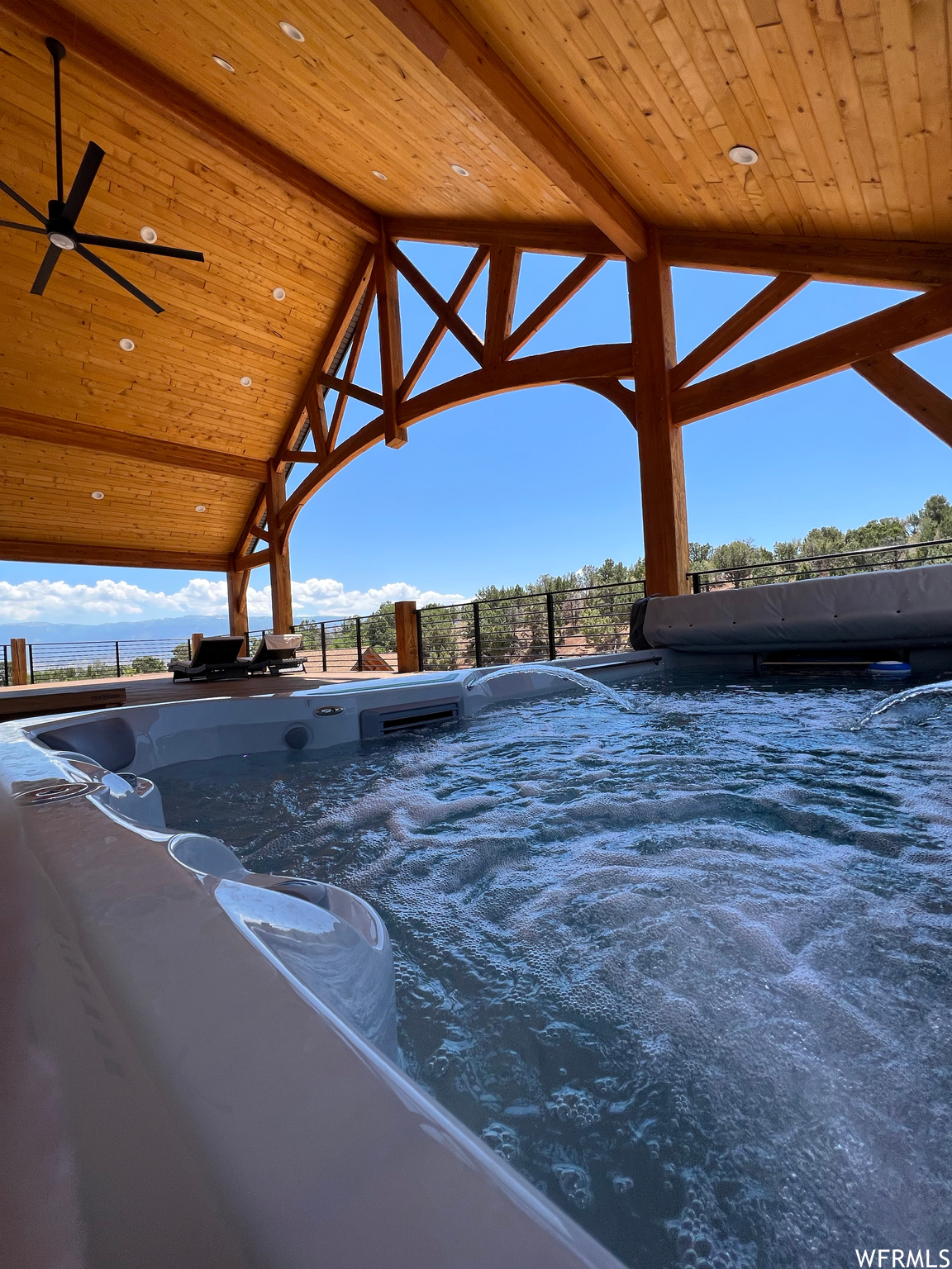 View of pool featuring a hot tub and ceiling fan