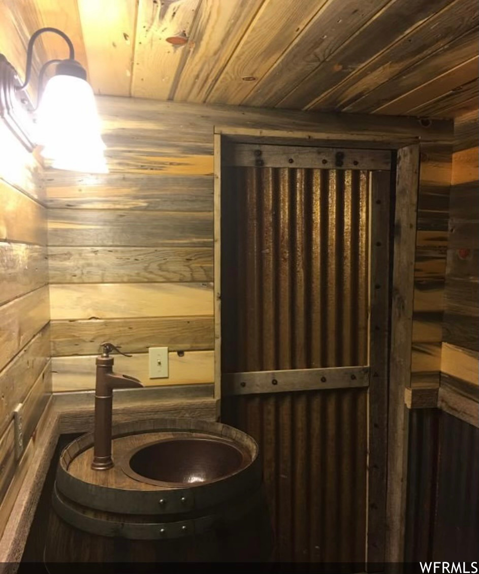 Bathroom with wood ceiling and wooden walls