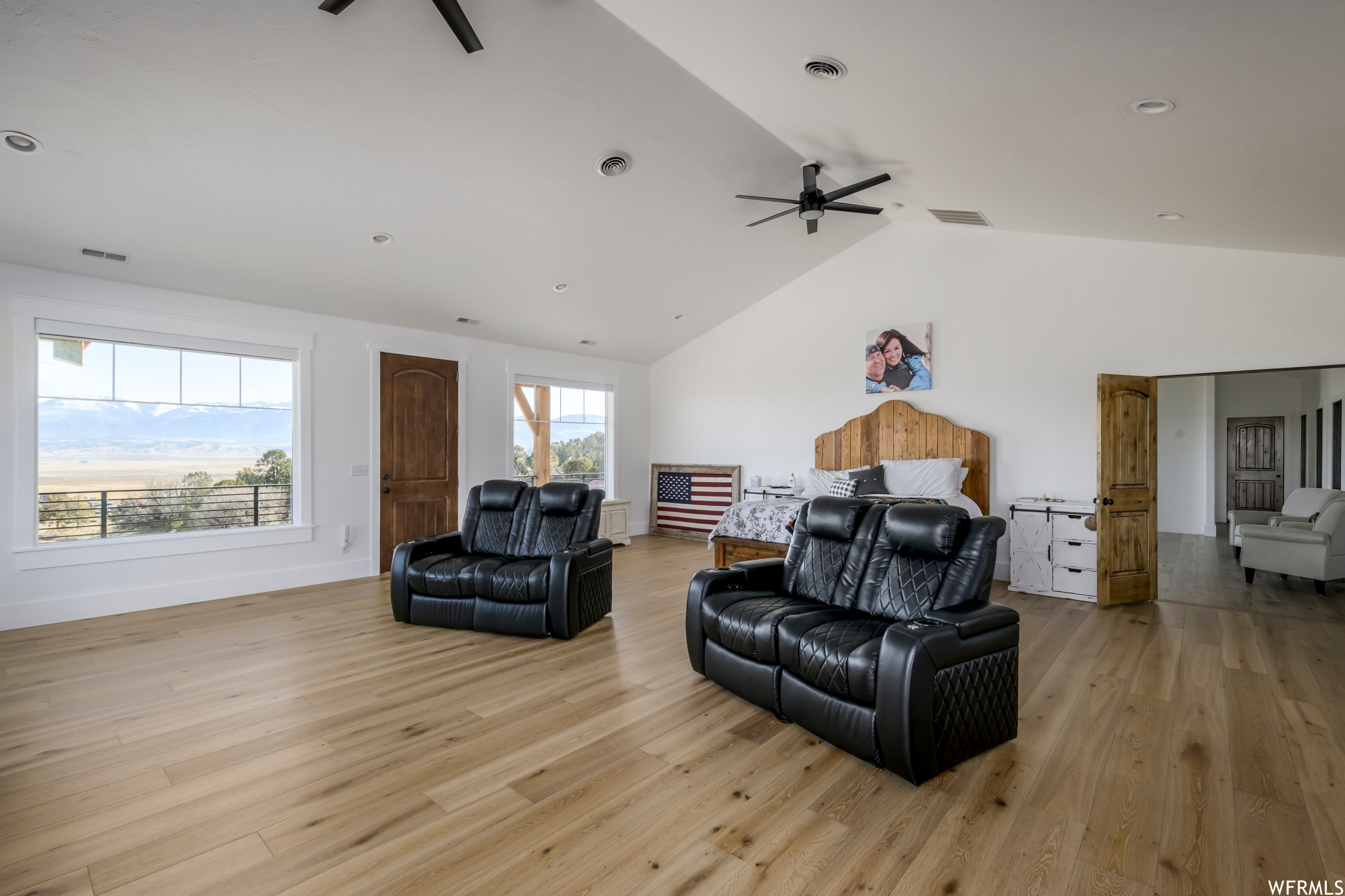 Living room featuring ceiling fan, light hardwood / wood-style flooring, and vaulted ceiling
