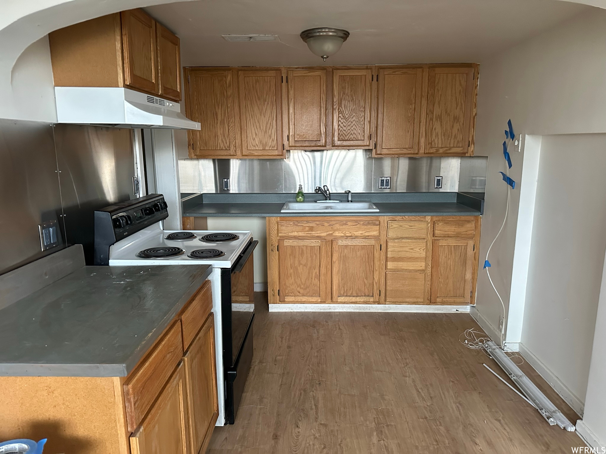 Kitchen featuring sink, white range with electric stovetop, and dark hardwood / wood-style flooring