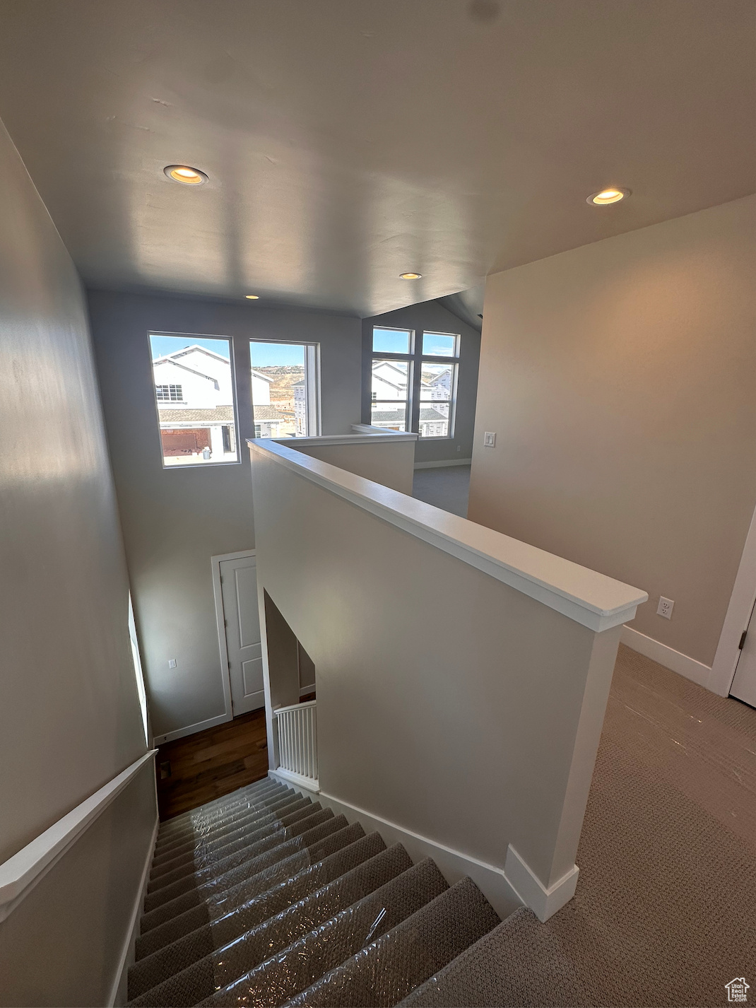 Staircase with lofted ceiling and carpet flooring