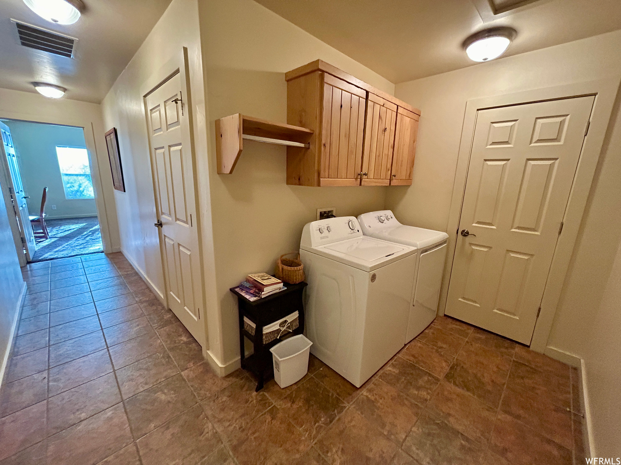 Washroom featuring washer hookup, cabinets, separate washer and dryer, and dark tile floors