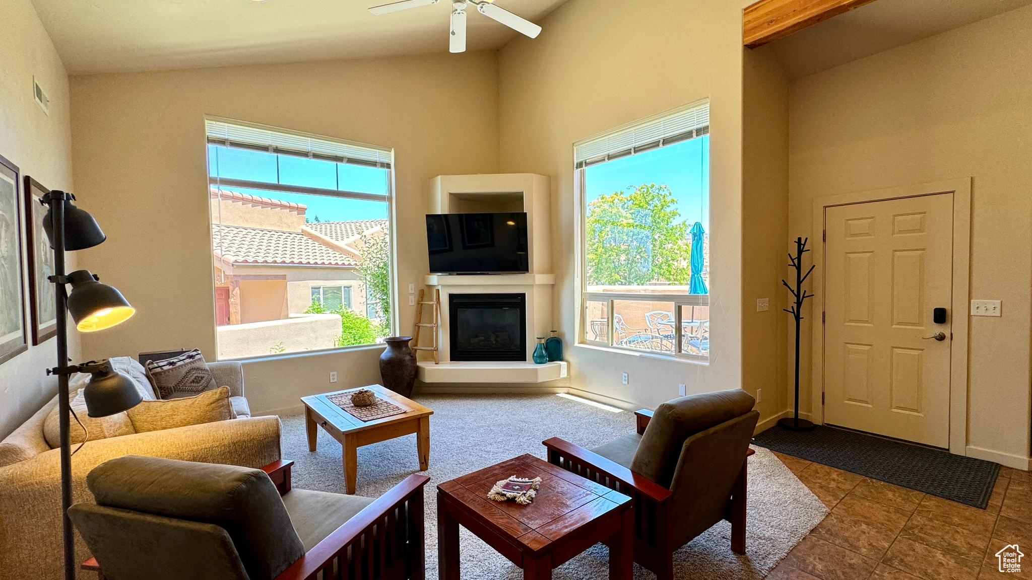 Living room featuring lofted ceiling, ceiling fan, and tile patterned flooring