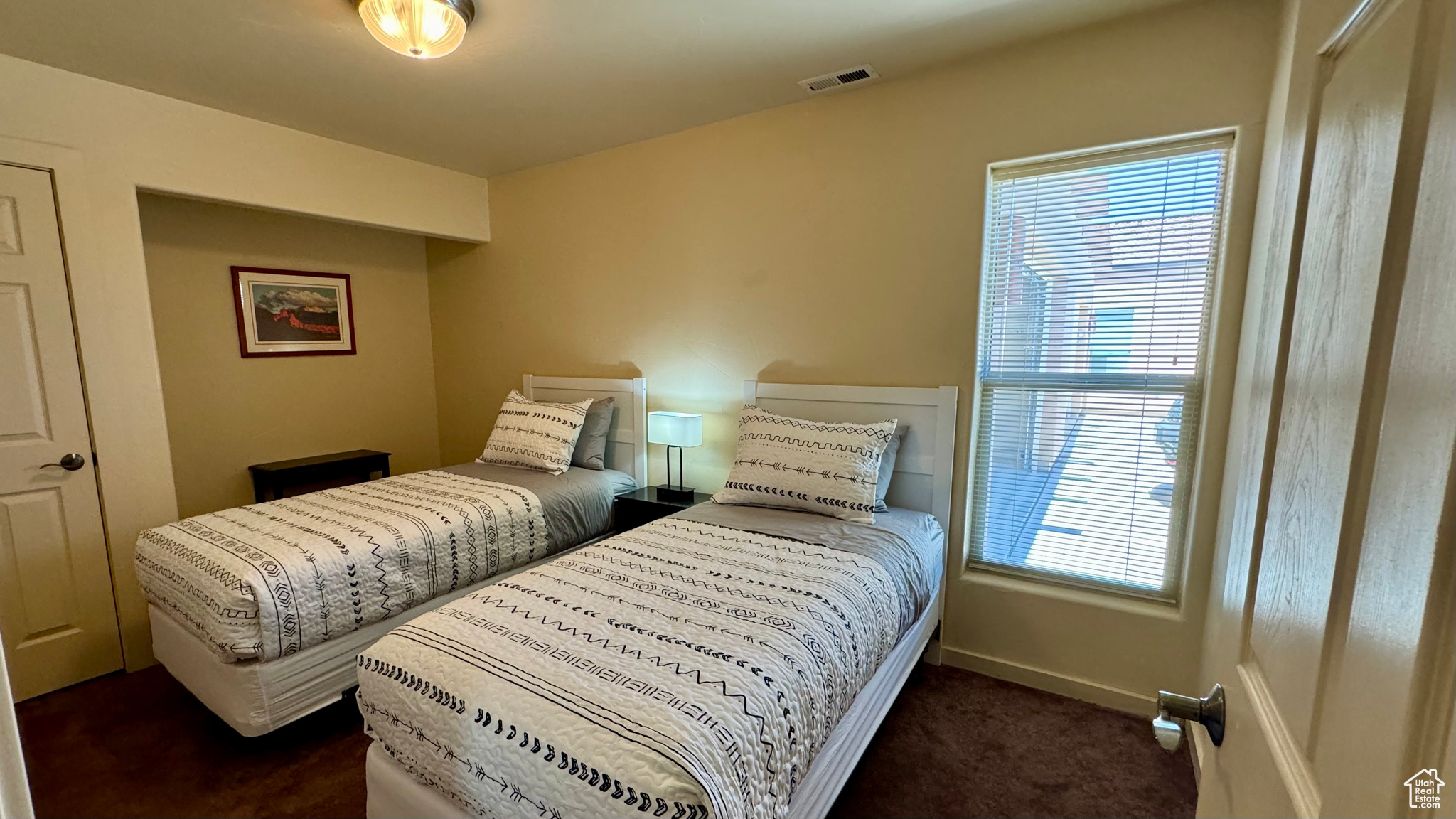 Carpeted bedroom featuring multiple windows