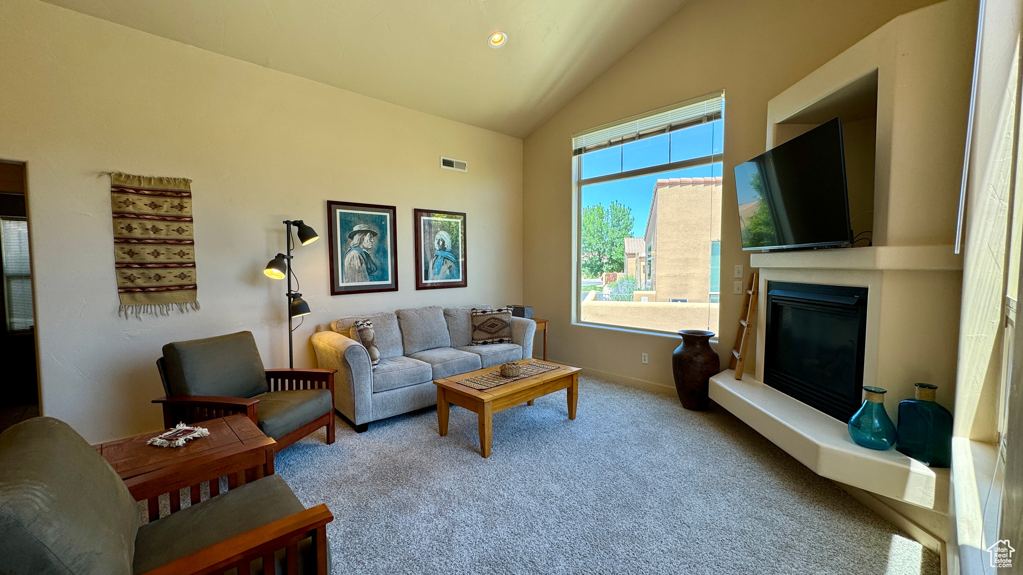 Carpeted living room featuring vaulted ceiling