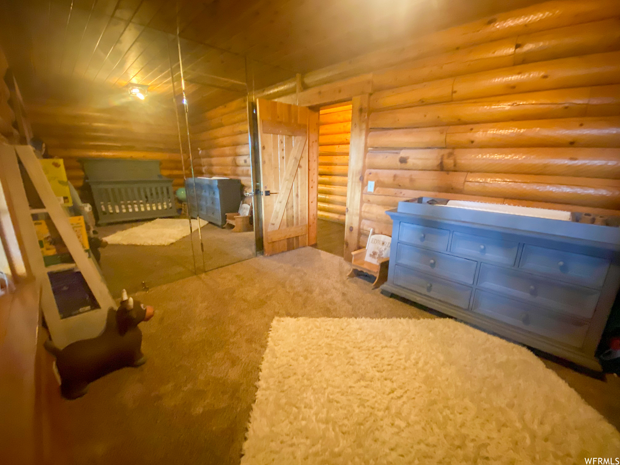 Unfurnished bedroom featuring log walls and a closet