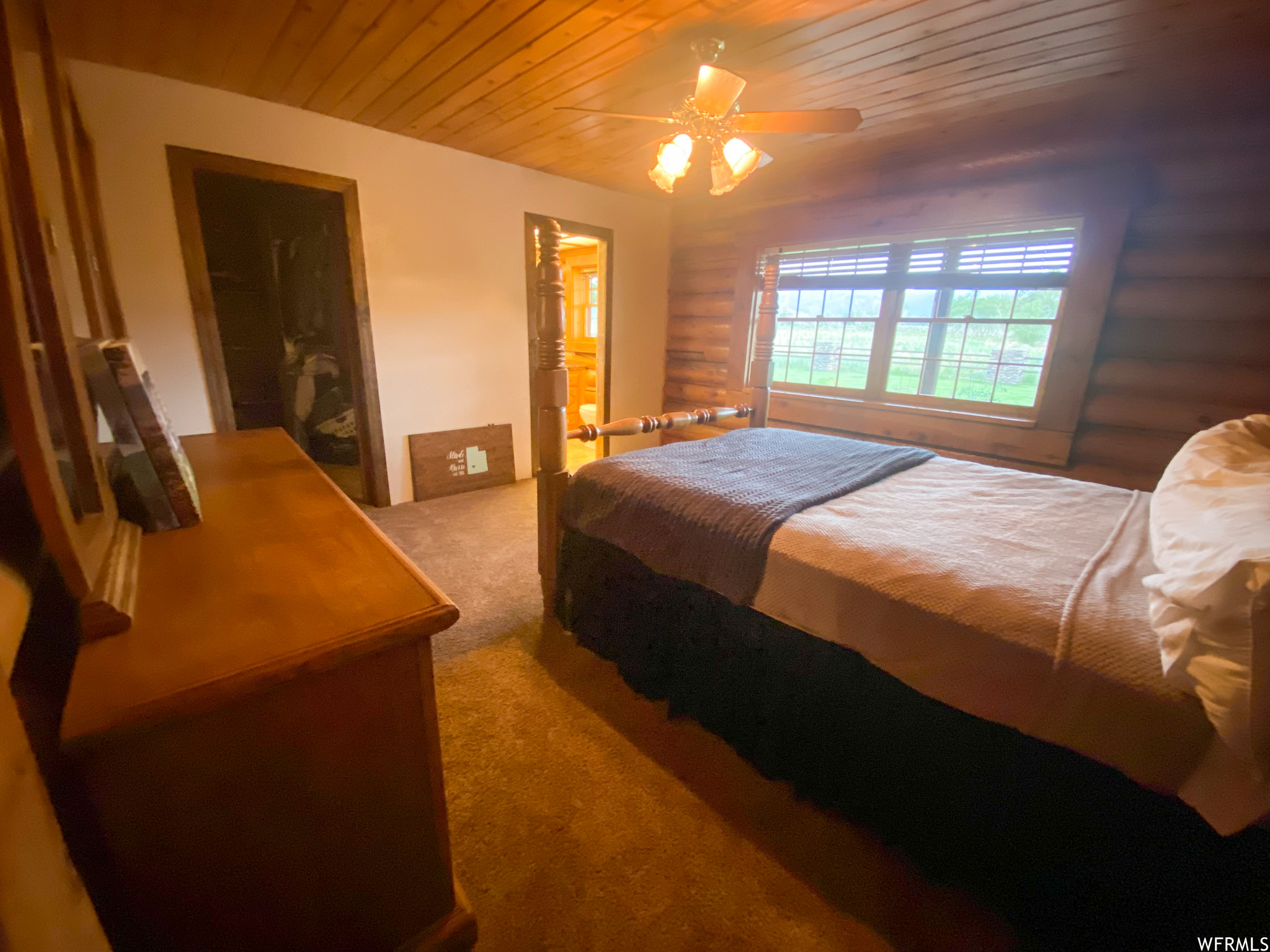 Bedroom featuring light colored carpet, wooden ceiling, and ceiling fan