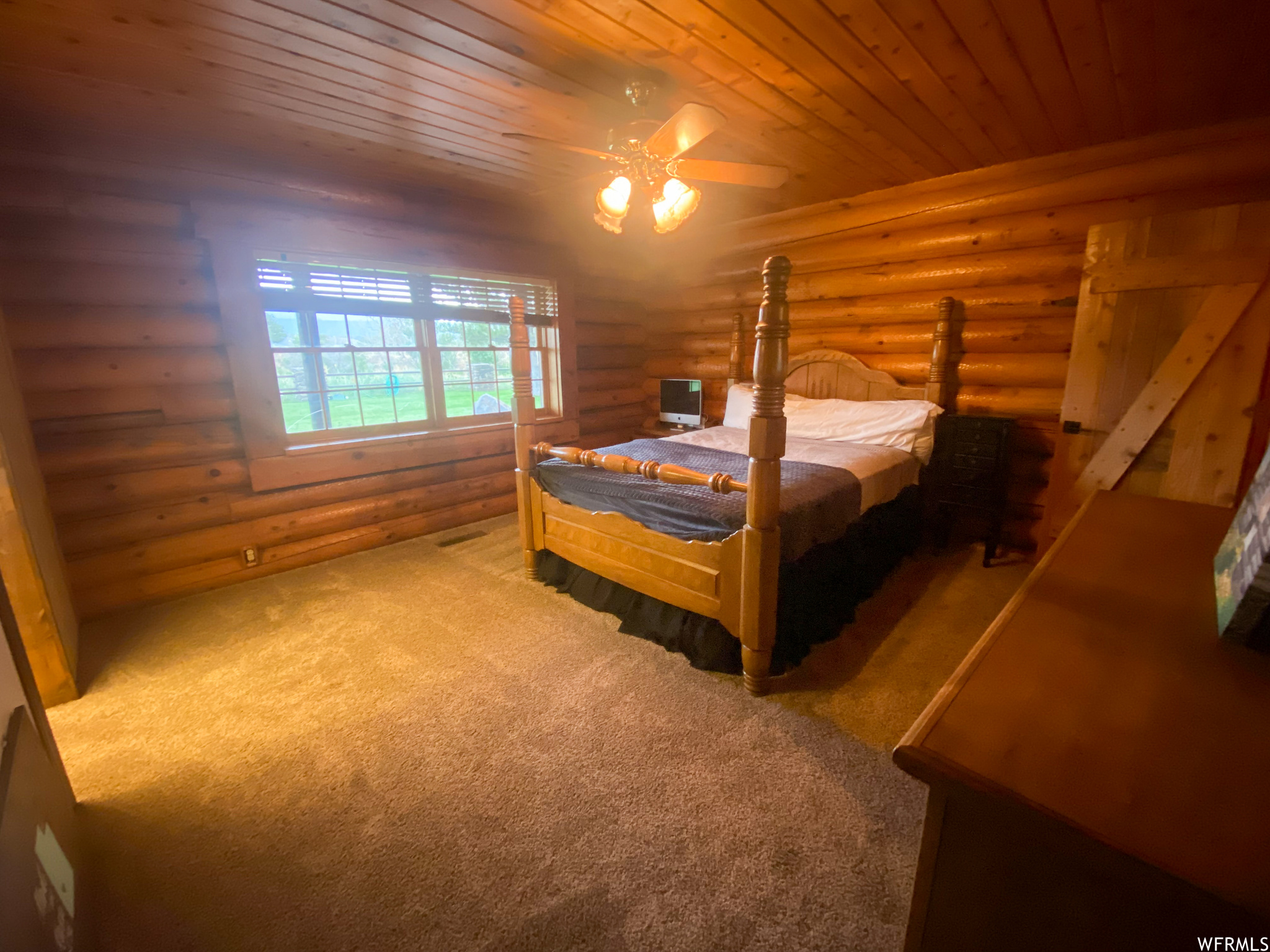 Bedroom with wood ceiling, carpet floors, log walls, and ceiling fan