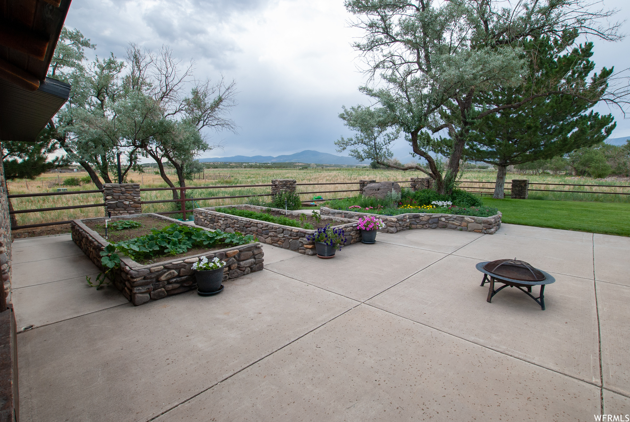View of terrace featuring a fire pit, a rural view, and a mountain view