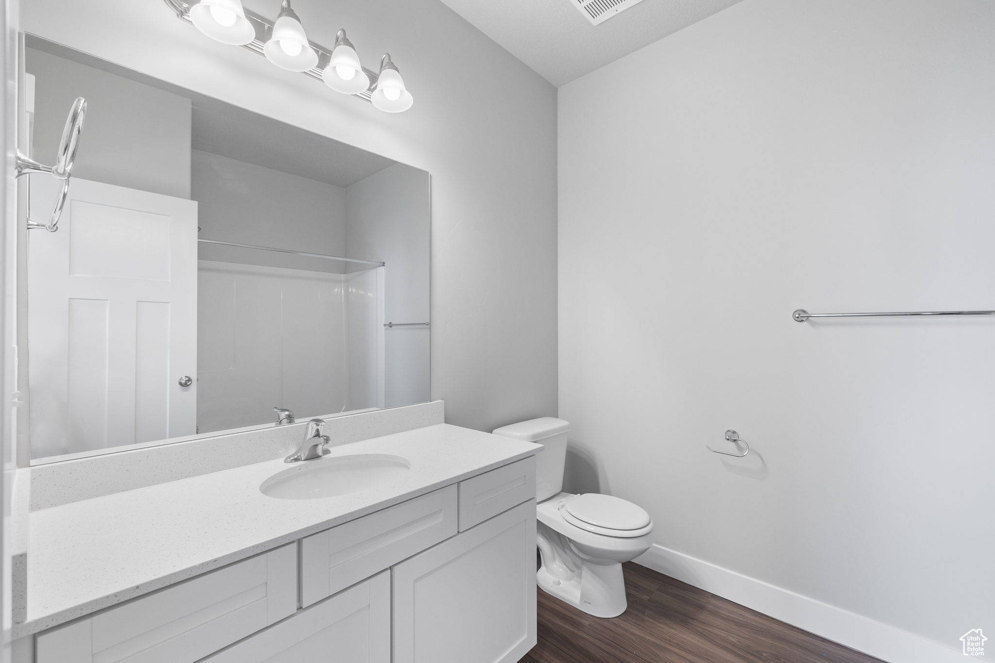 Bathroom featuring hardwood / wood-style floors, vanity, and toilet