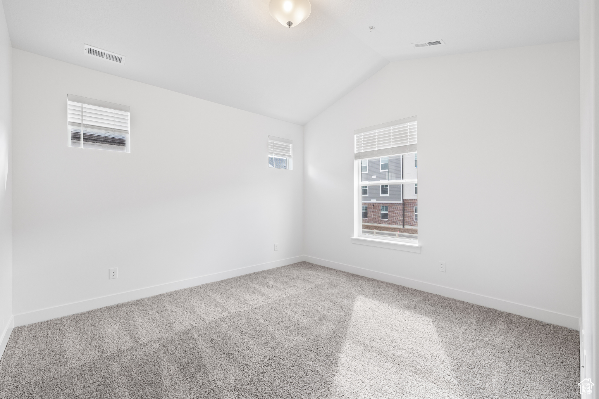 Spare room with lofted ceiling and carpet flooring