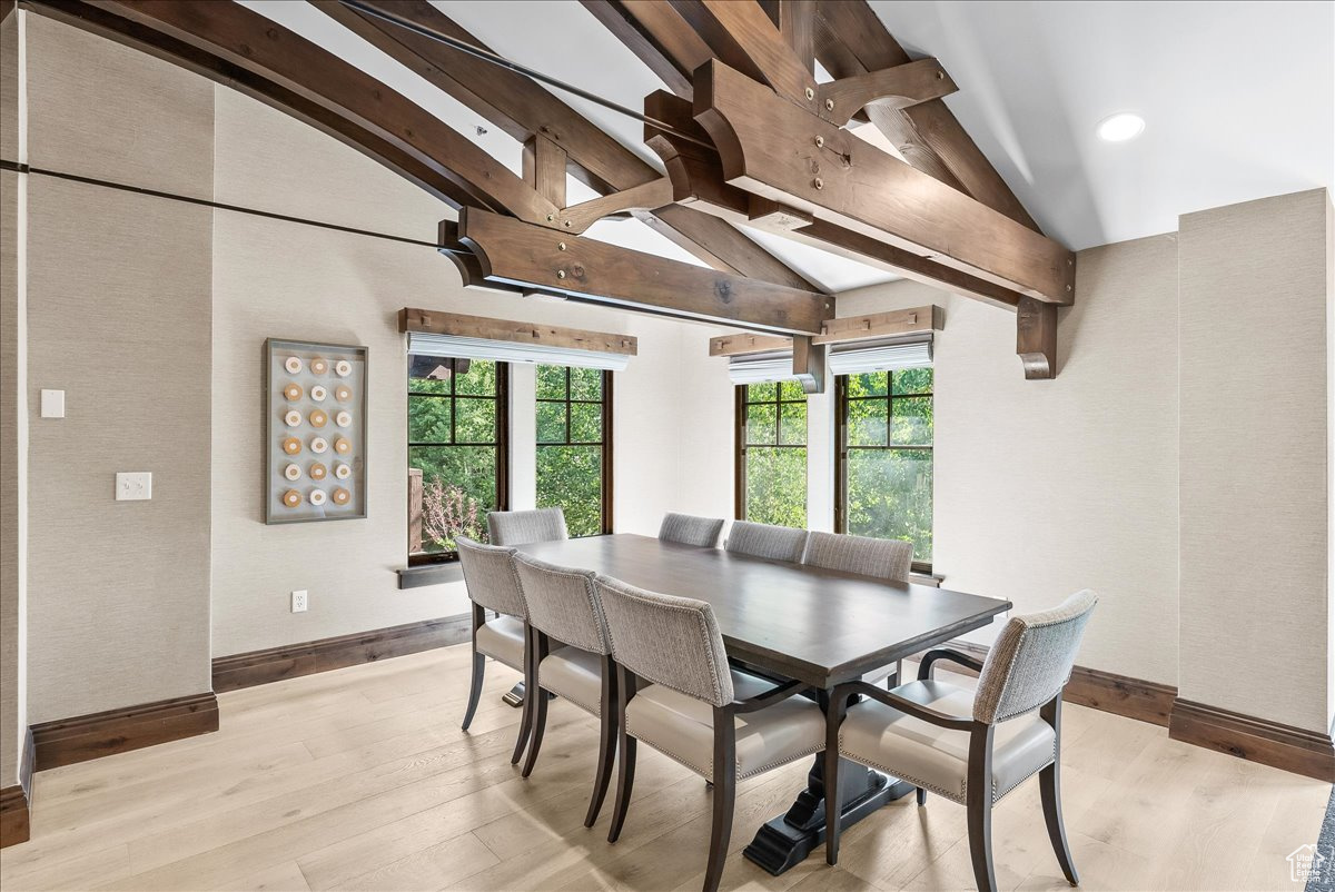 Dining space featuring beam ceiling, plenty of natural light, and light hardwood / wood-style flooring