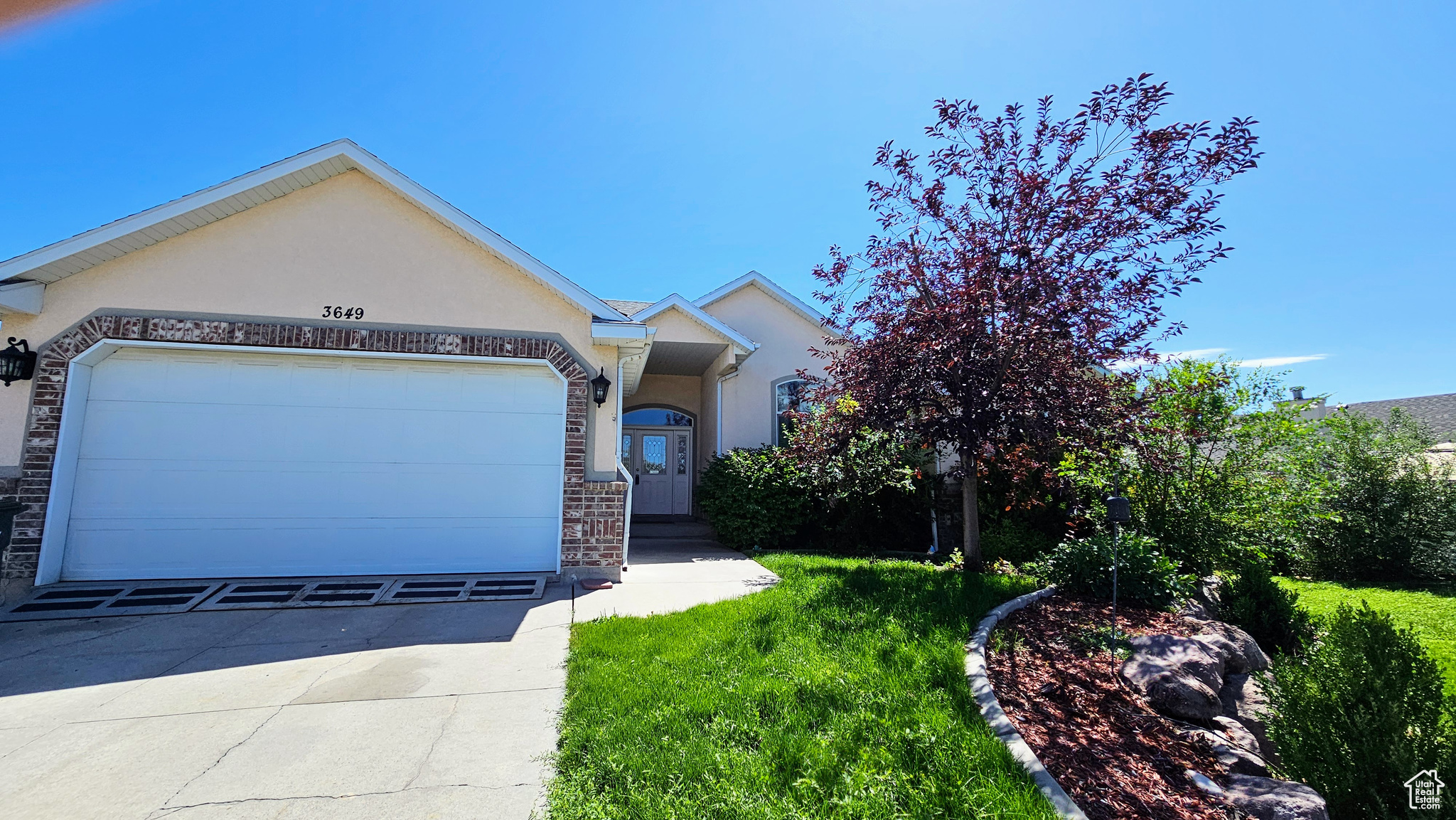 View of front of house featuring a garage and a front lawn