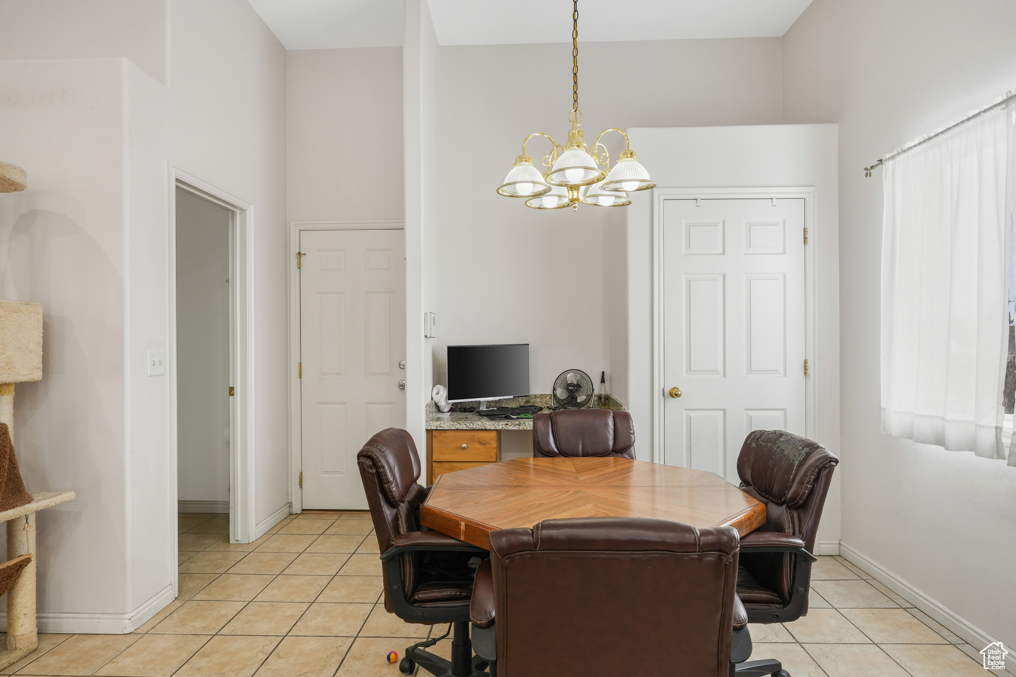 Office space featuring a chandelier, a high ceiling, and light tile floors
