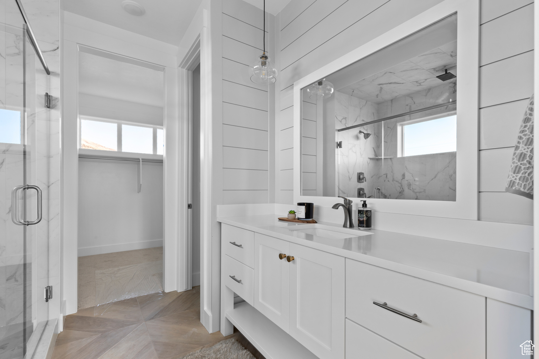 Bathroom featuring vanity with extensive cabinet space, parquet floors, and an enclosed shower