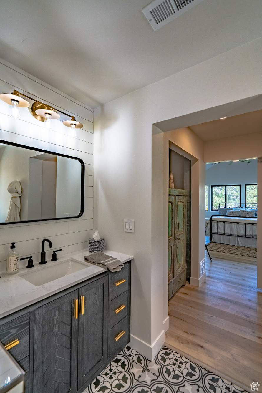 Bathroom featuring vanity, backsplash, and hardwood / wood-style floors