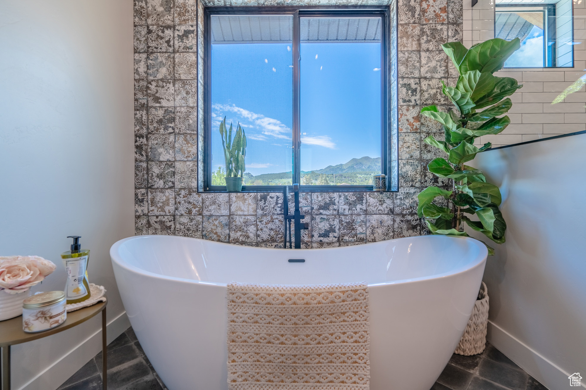 Bathroom featuring tile floors, tile walls, and a tub