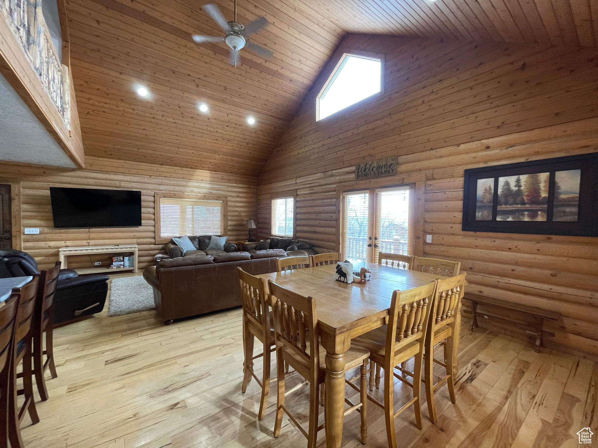 Dining space with light wood-type flooring, high vaulted ceiling, wooden ceiling, and ceiling fan
