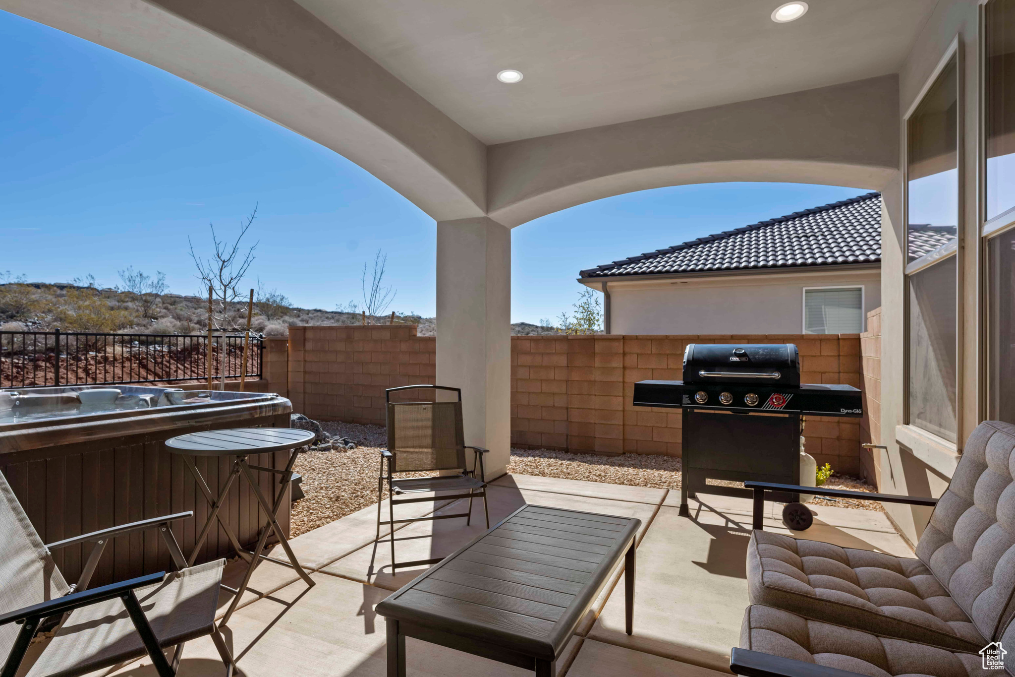 View of patio with grilling area and a hot tub