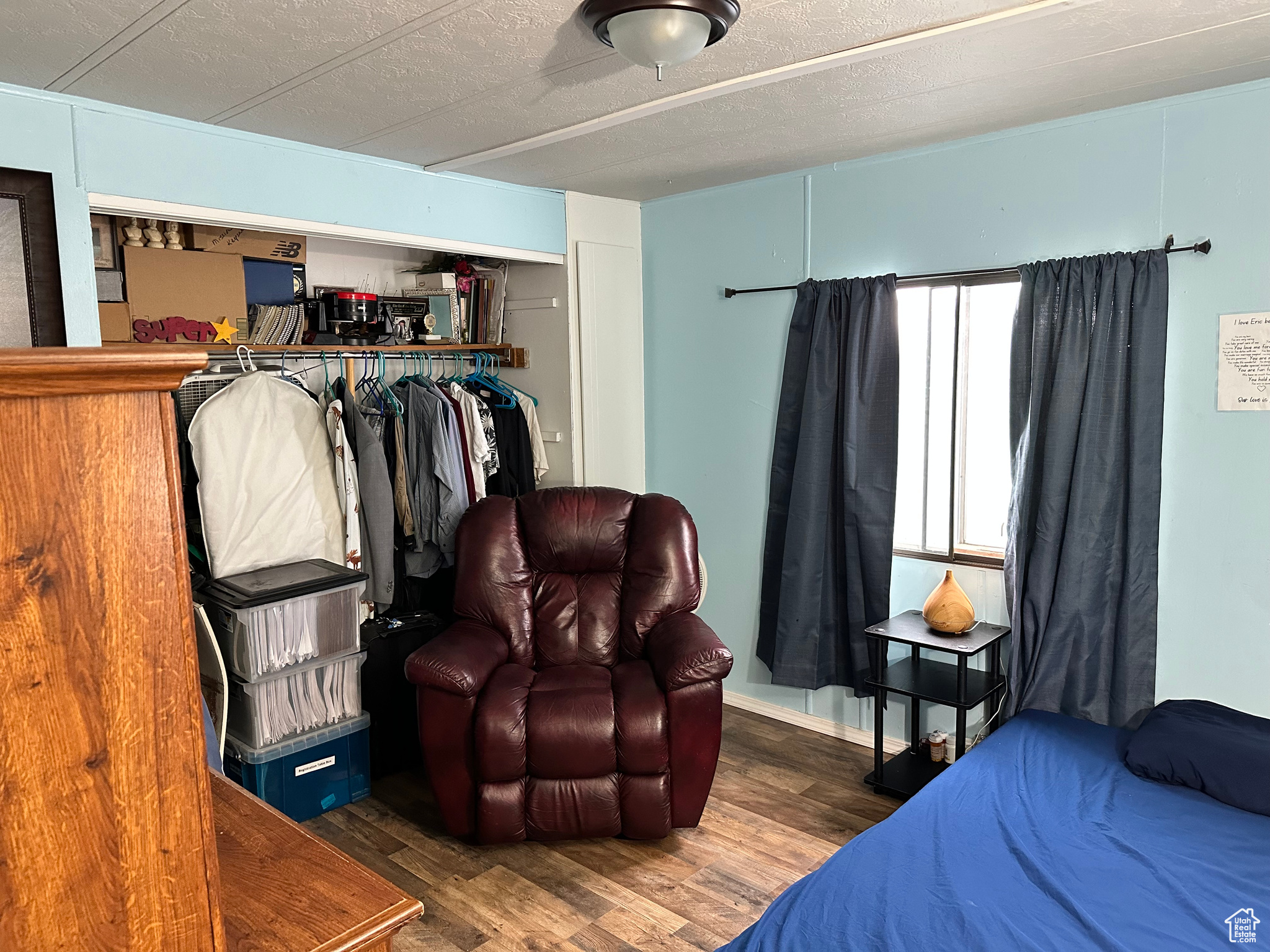Bedroom with dark hardwood / wood-style flooring and a closet