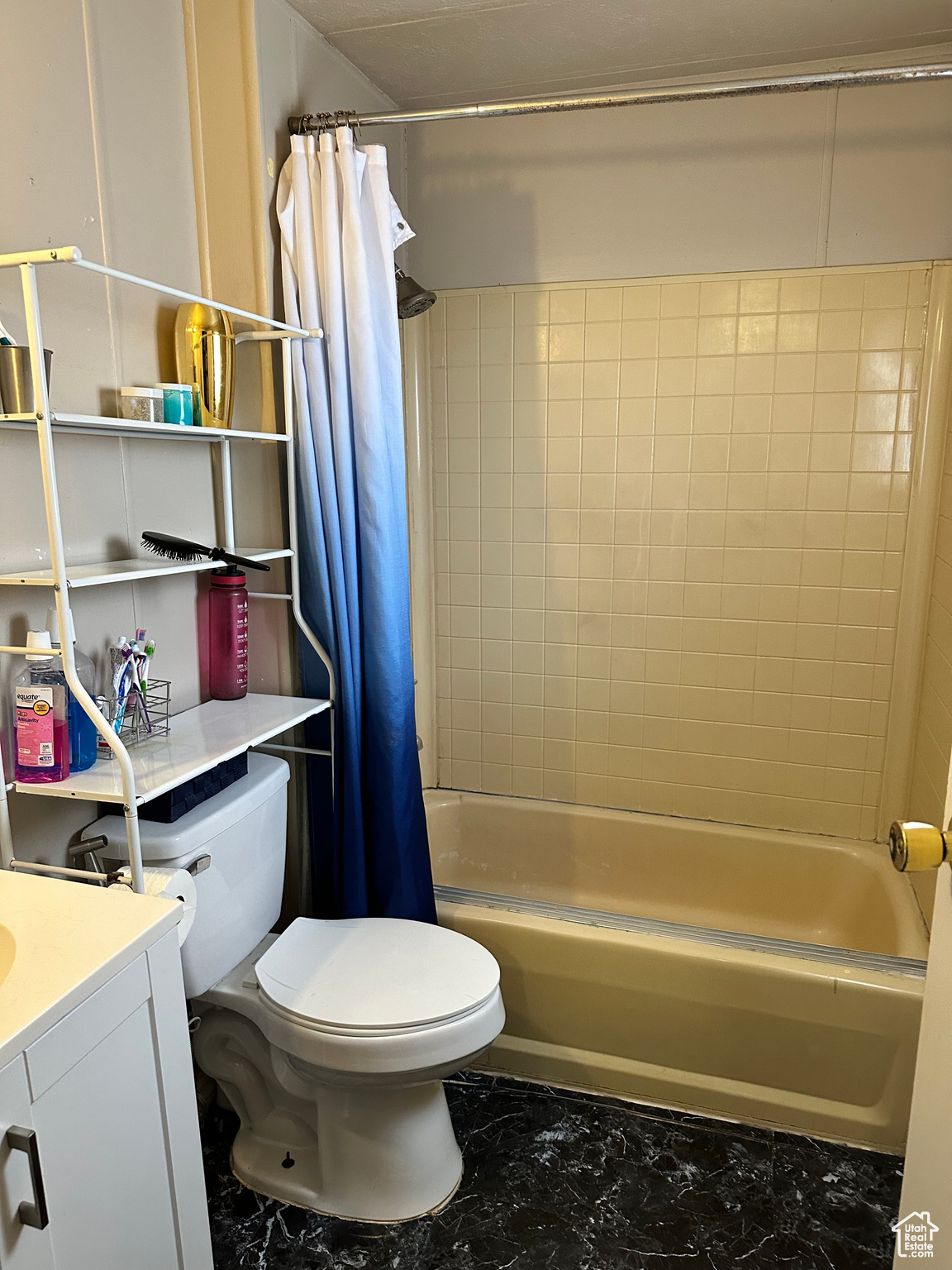 Full bathroom with vanity, toilet, tile flooring, and shower / bathtub combination with curtain