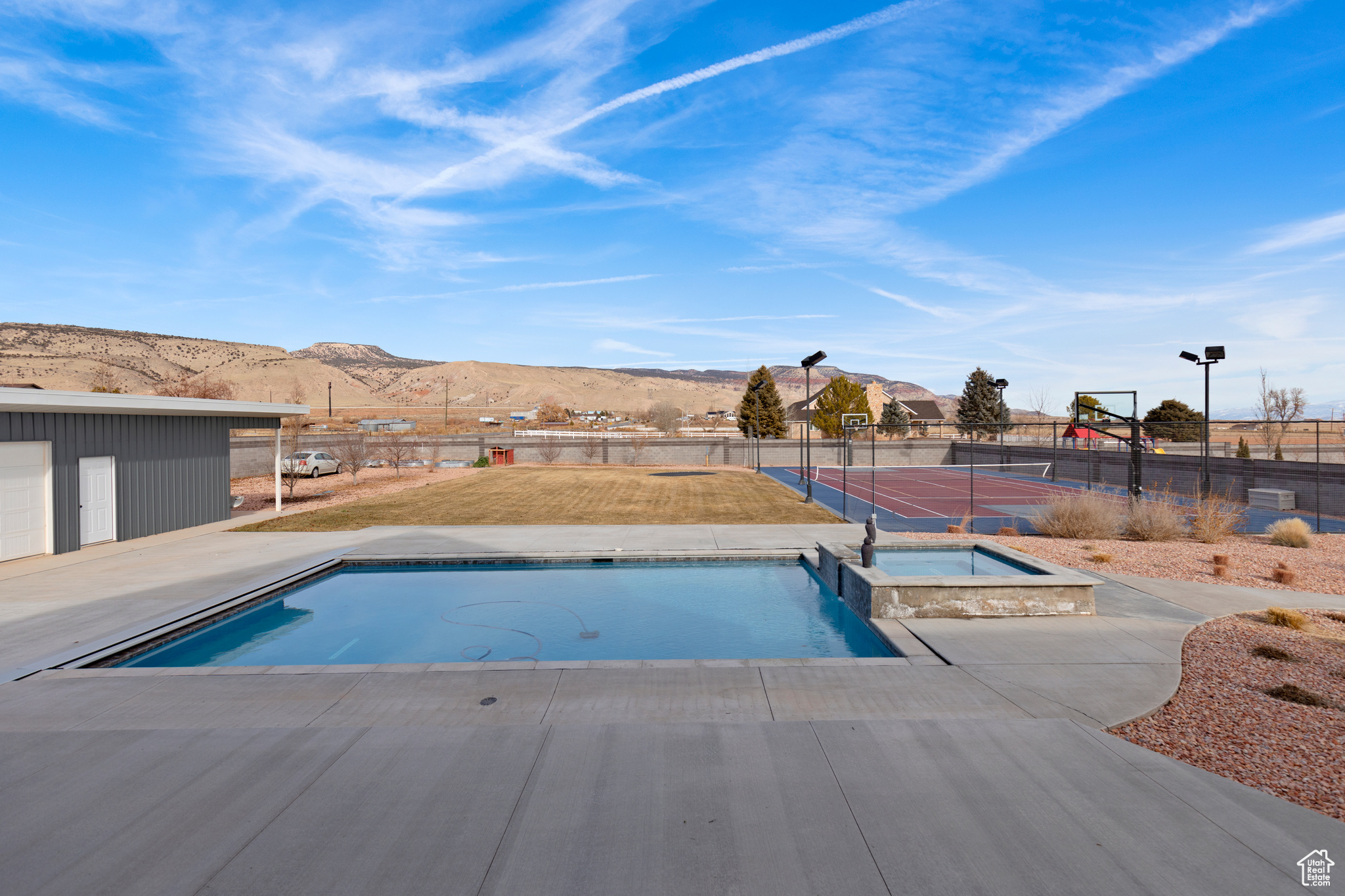 View of pool with a mountain view and an in ground hot tub