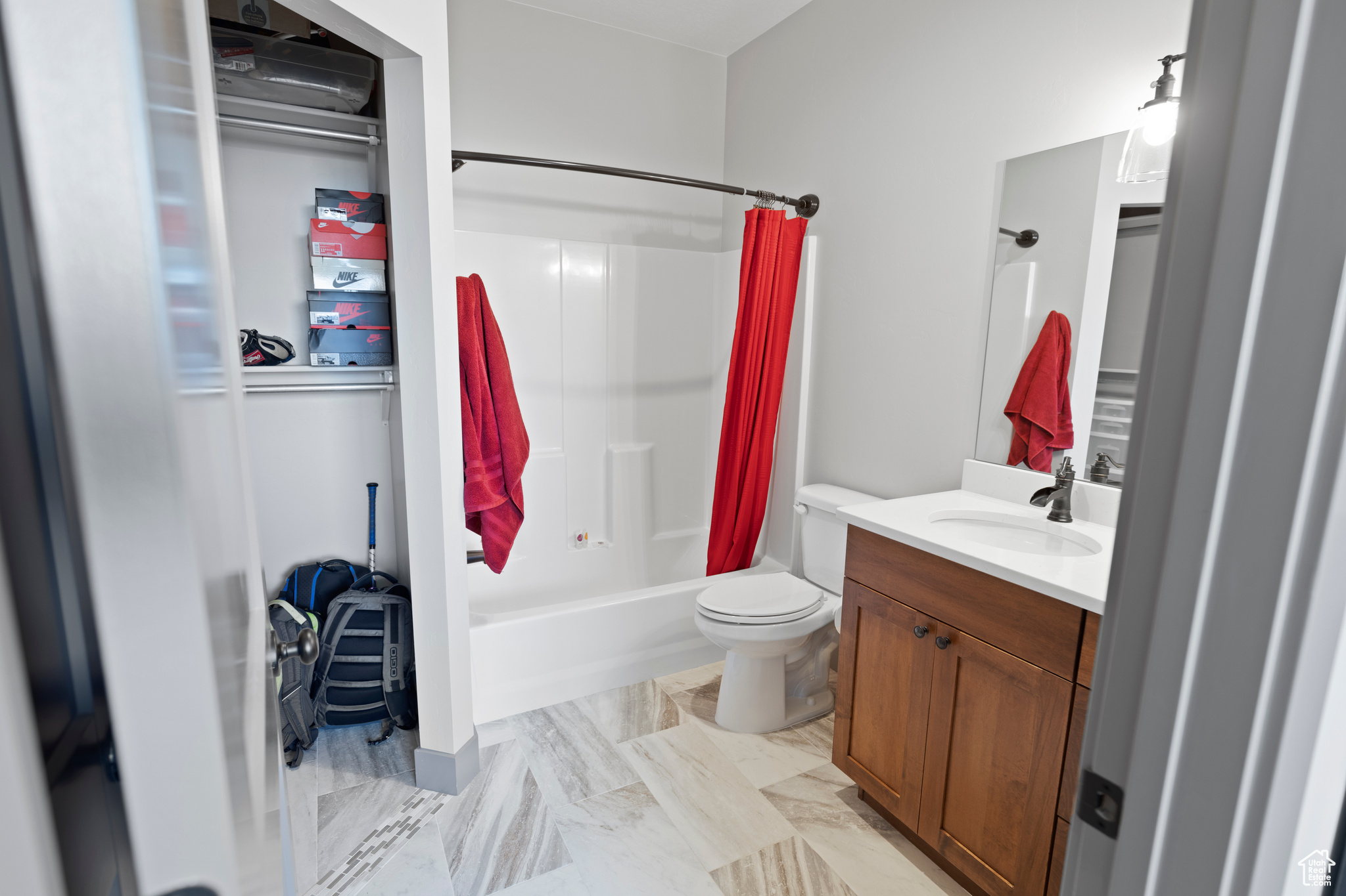 Full bathroom featuring tile floors, vanity, shower / tub combo with curtain, and toilet