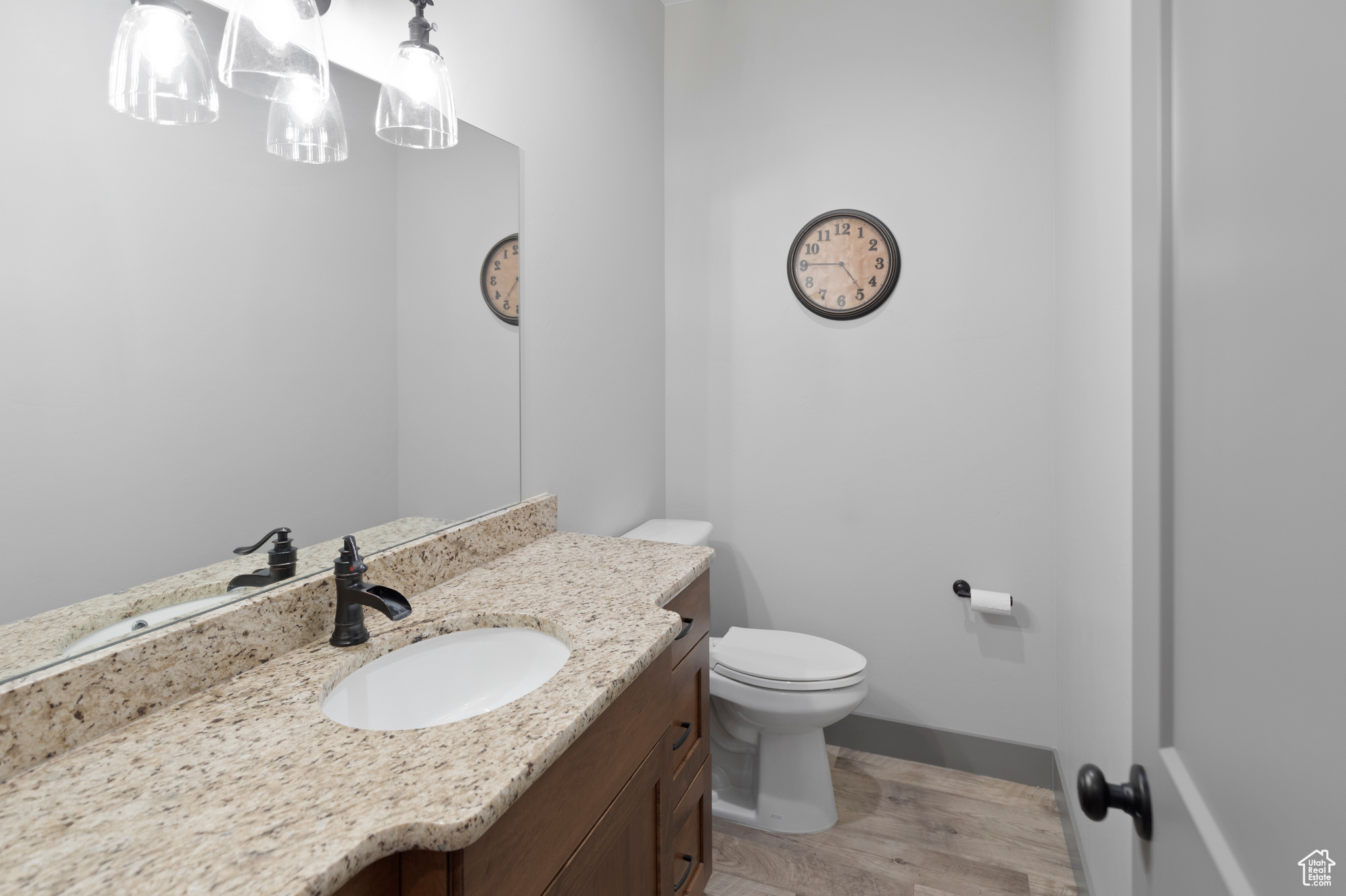 1/2 Bathroom with vanity, toilet, and hardwood / wood-style floors