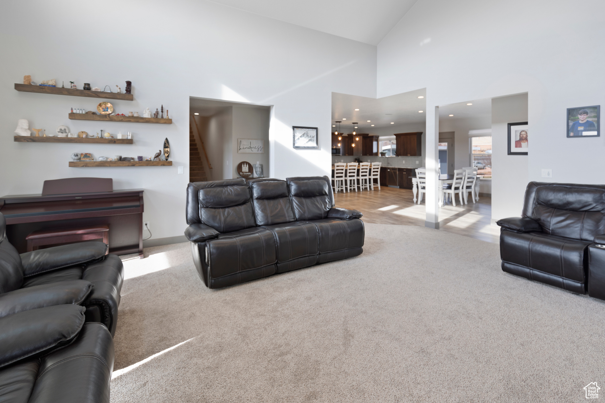 Living room featuring light carpet and high vaulted ceiling