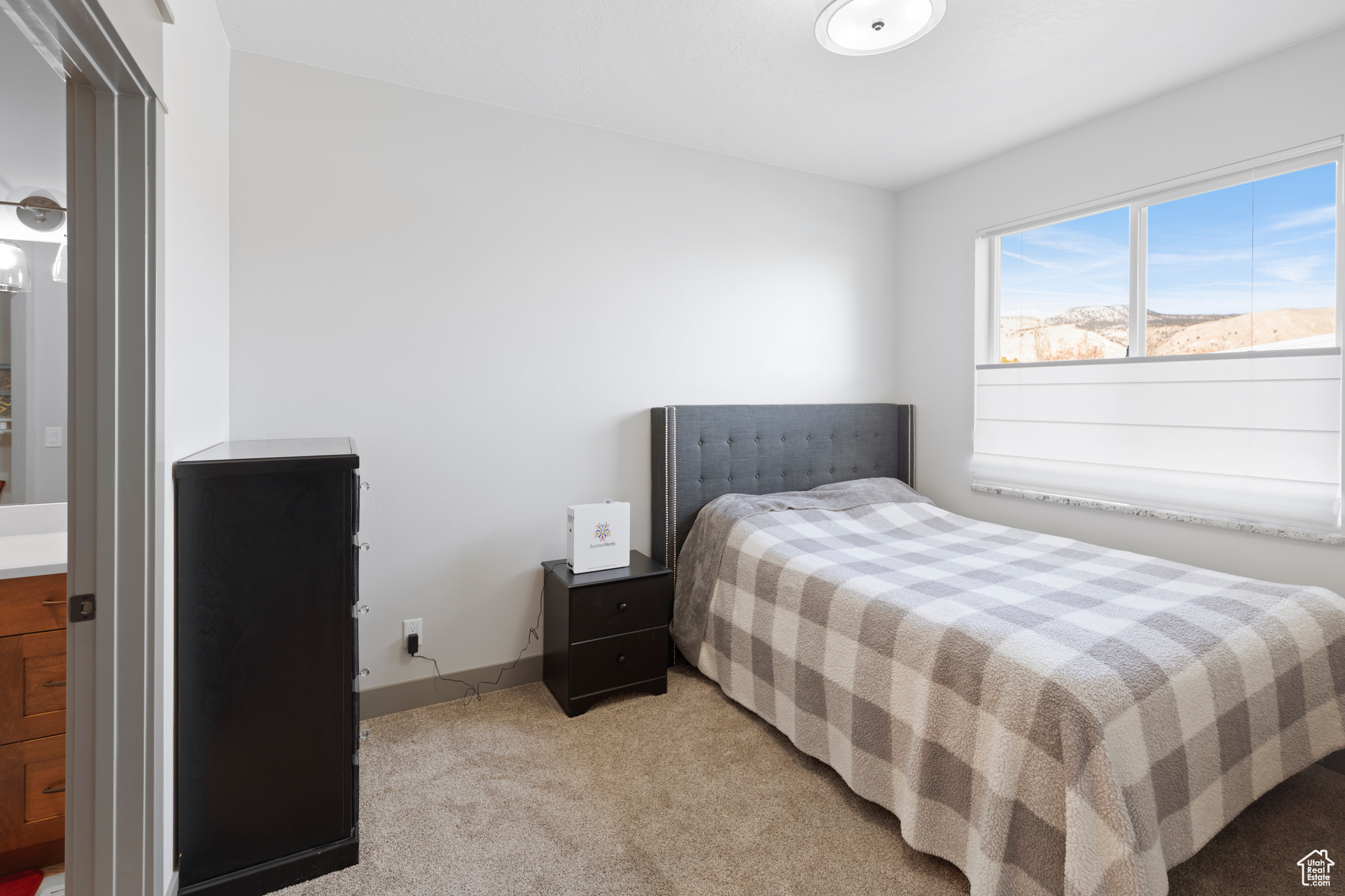 Bedroom with light colored carpet featuring connected bathroom